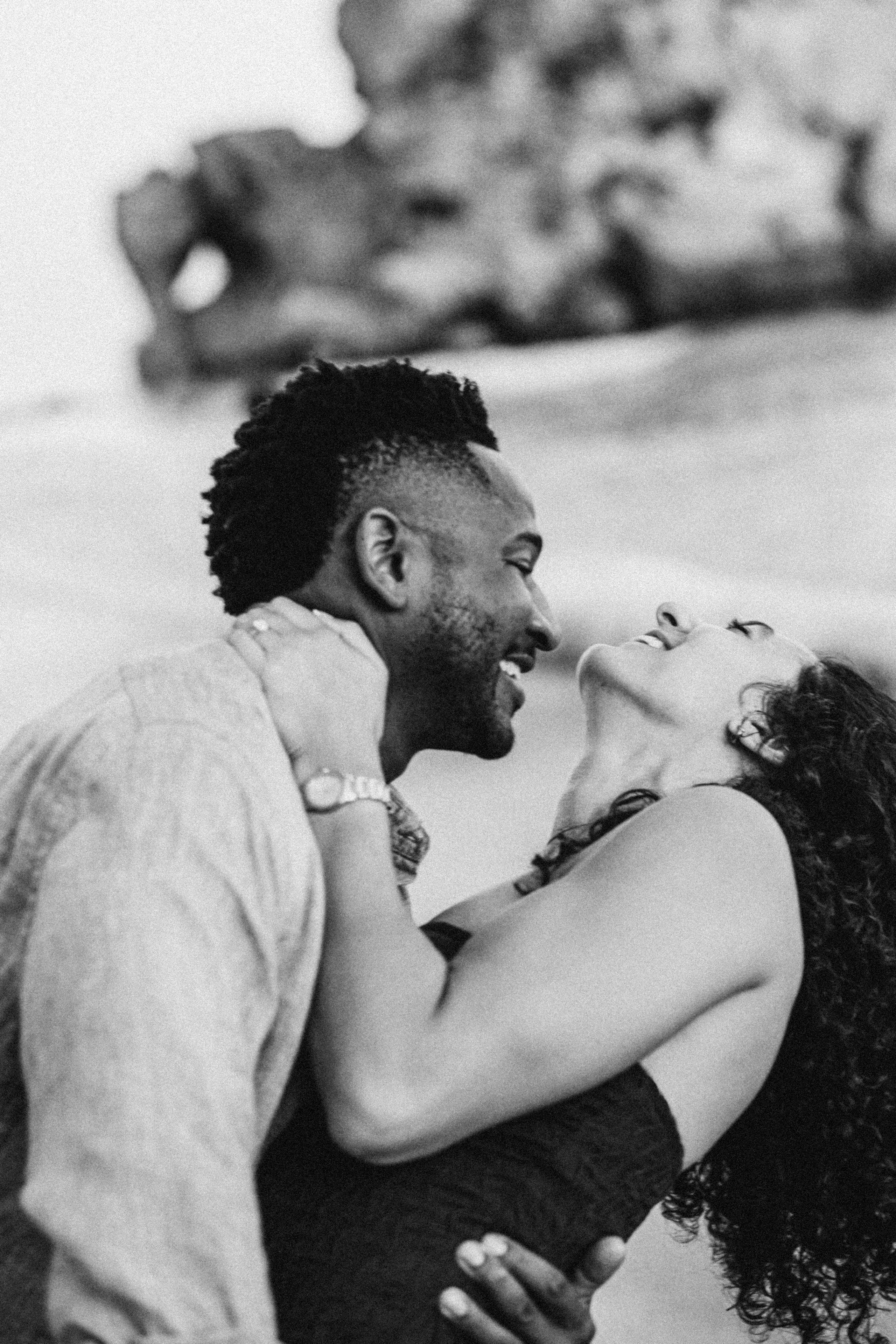 Momento espontáneo y alegre entre una pareja durante una sesión de historia de amor en Valencia, España — ideal para quienes desean capturar conexión genuina y emoción en su sesión de pareja en la costa española.