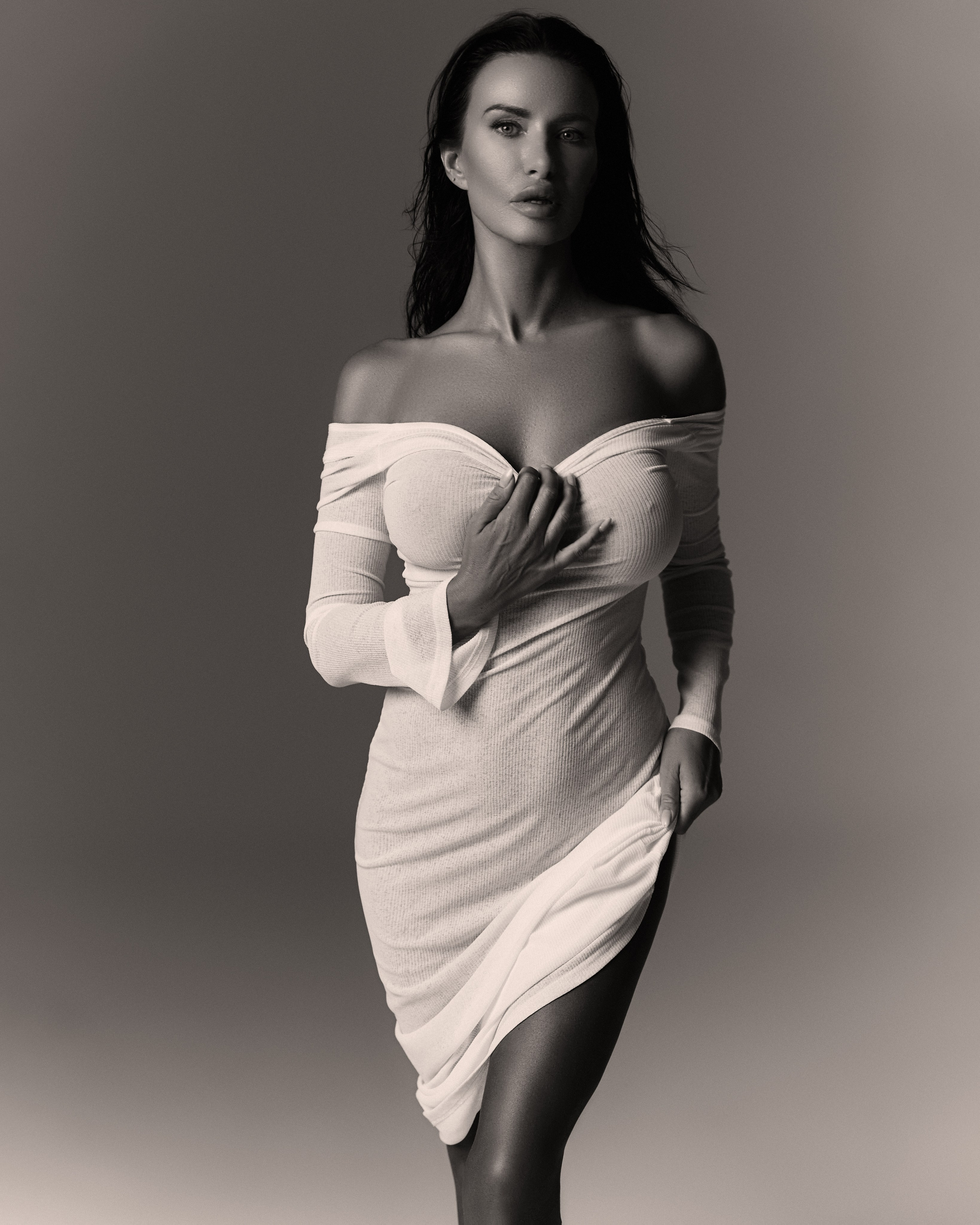Sensual fashion portrait by photographer Hanna Asaulova | Model in elegant off-shoulder dress, professional black and white photography in Vilnius.