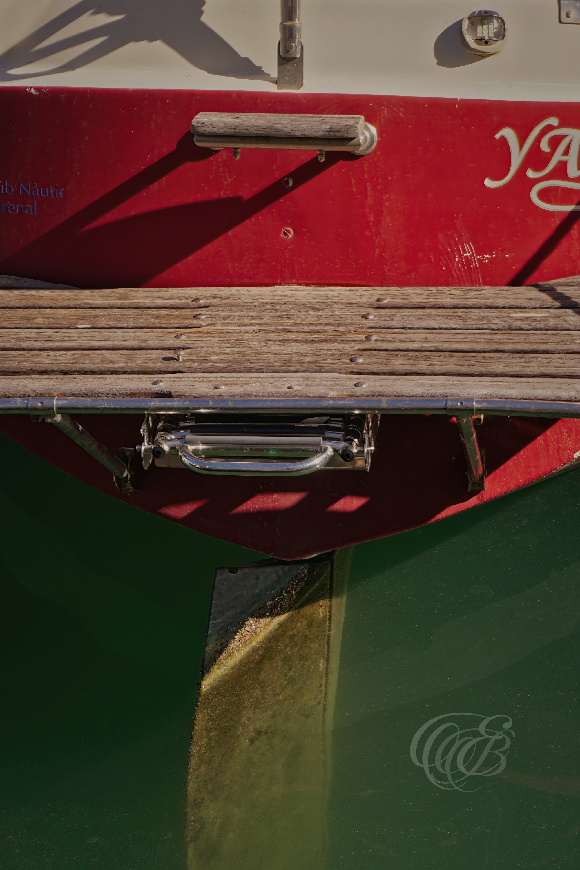A vintage boat sits moored by a quiet dock along the island’s coastline, showing the marks of time on its wooden structure and weathered surface. The scene reflects the everyday maritime life of Mallorca, where small harbors hold both working vessels and older boats preserved by routine use and salt air. The water remains still around the pier, reinforcing the calm atmosphere of the port. Eduardo Bartoli Photography.