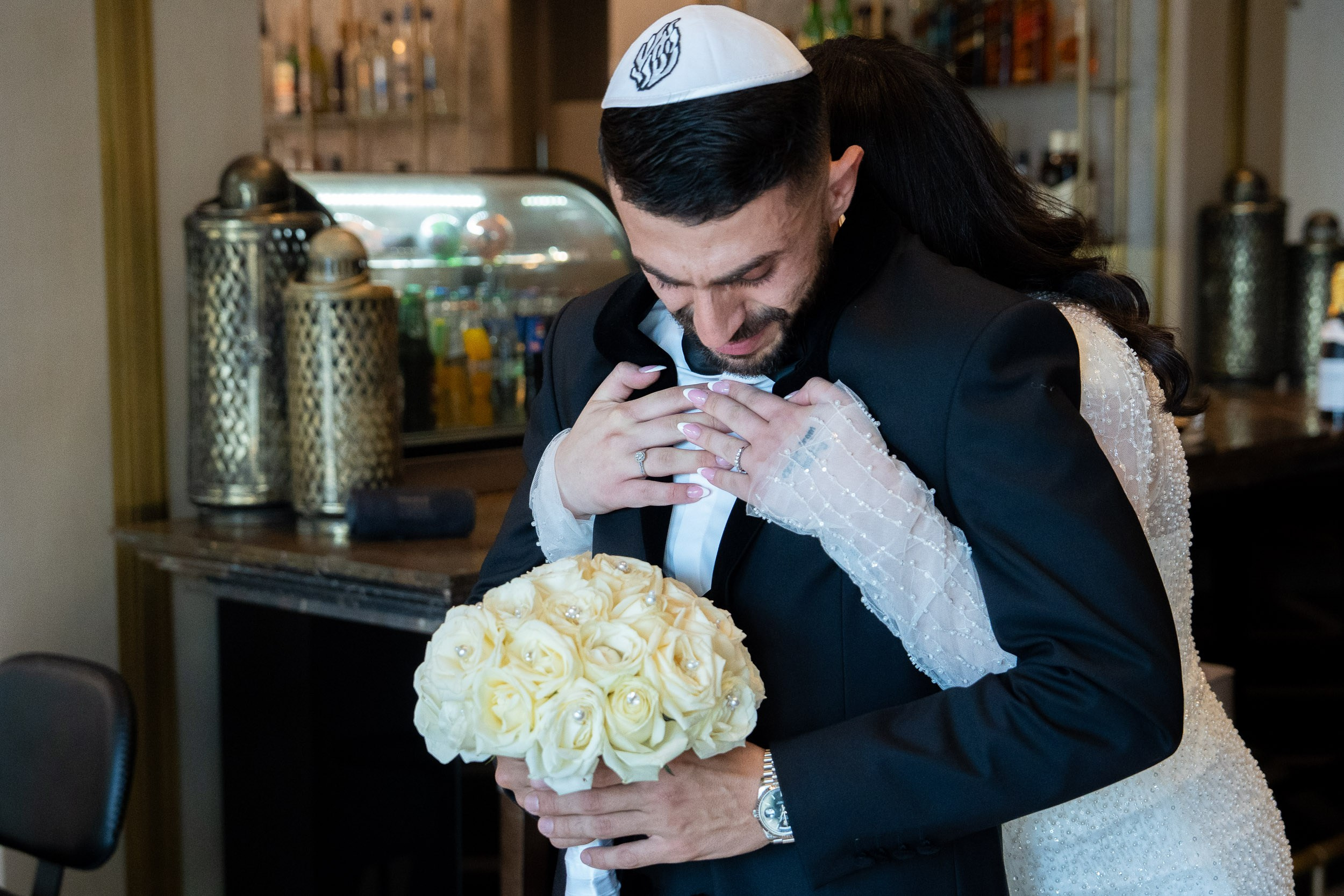 Bride Natali embracing groom Shimon from behind during their emotional first look in Netanya, Israel