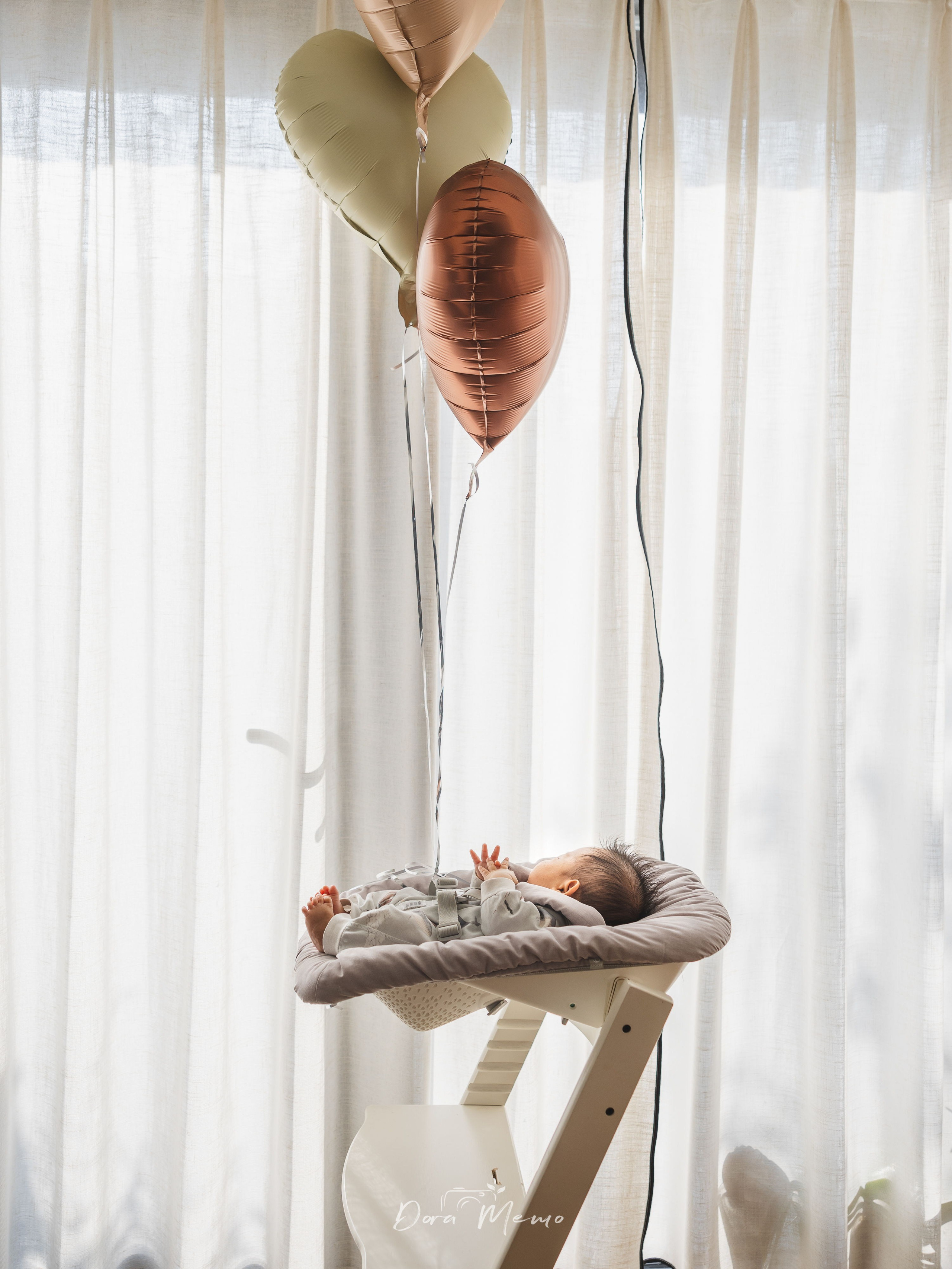 One-month-old baby resting in a high chair under soft natural light at home, photographed in Shanghai family photography session.