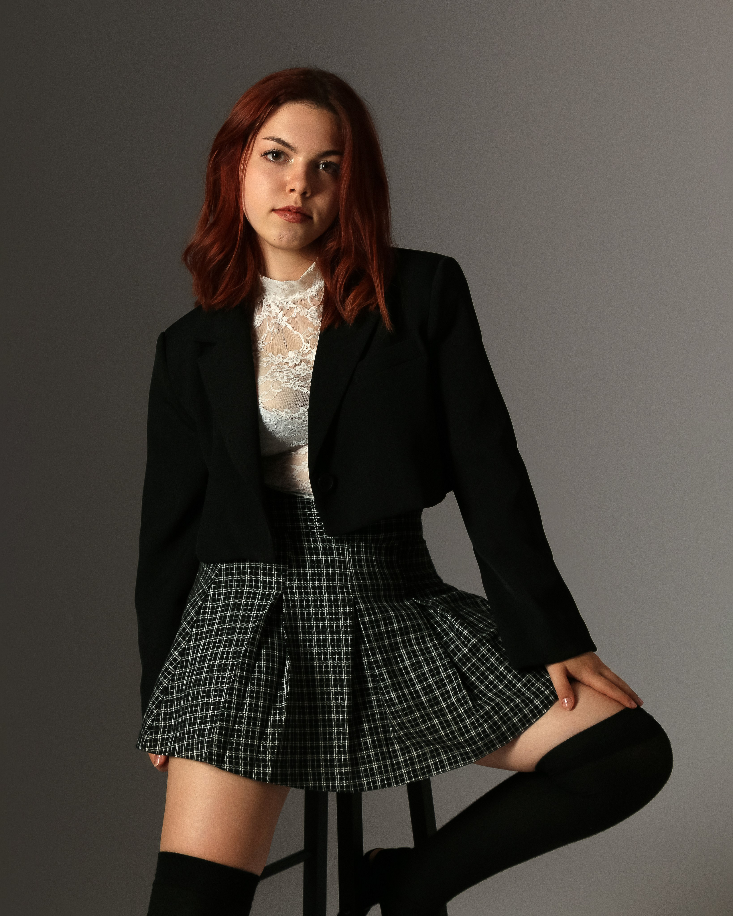 Stilvolle Studioaufnahme mit dunklem Hintergrund – Mariia in klassischem Rock-Outfit