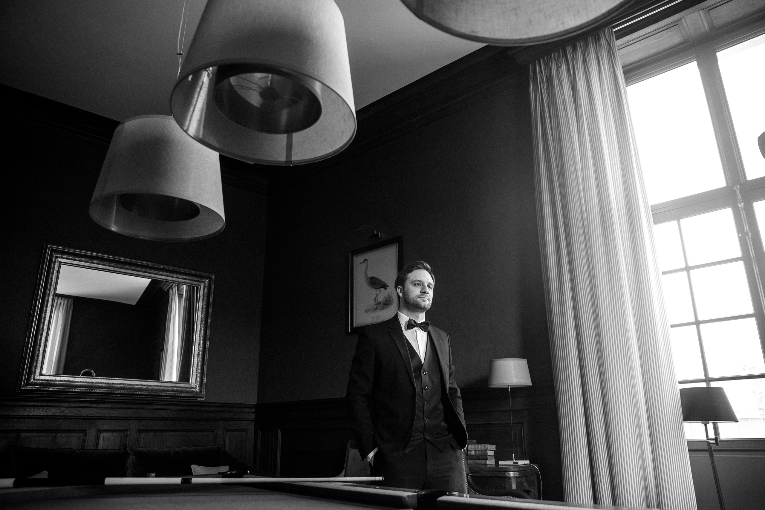 Groom portrait taken in a French chateau, showcasing a relaxed and elegant vibe for a destination wedding.