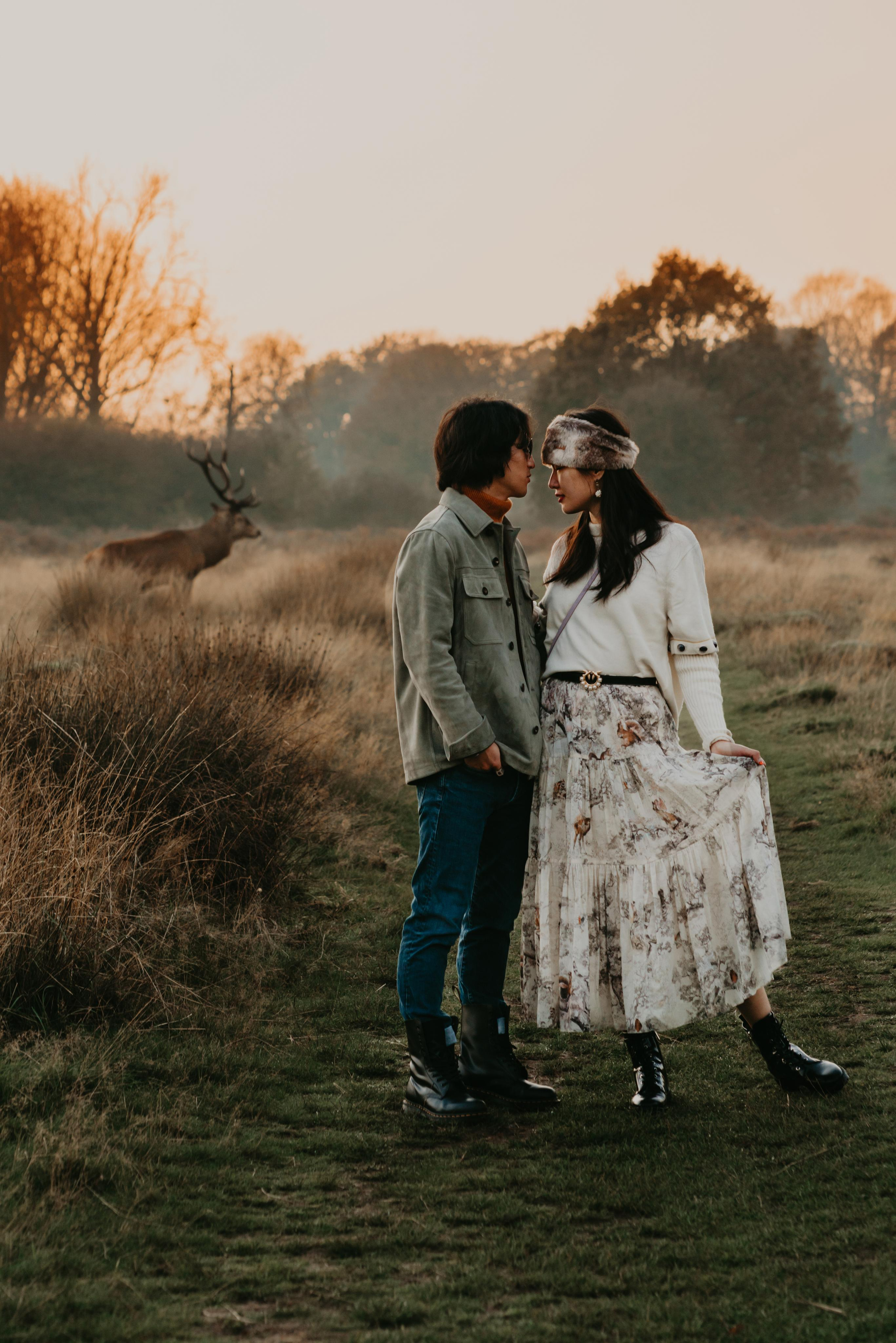 couple posing with deers in the park