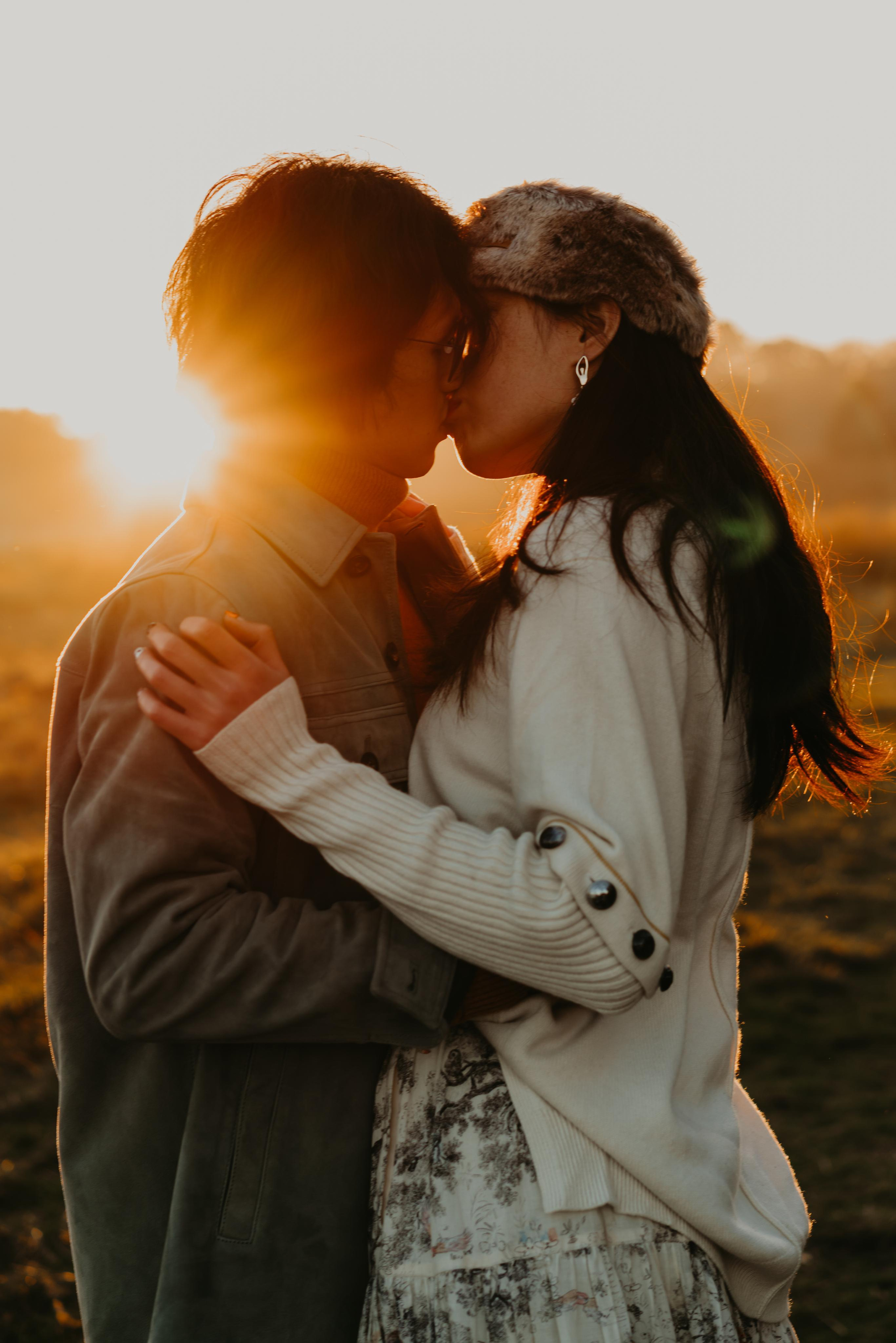 young couple kissing with sunset lights 