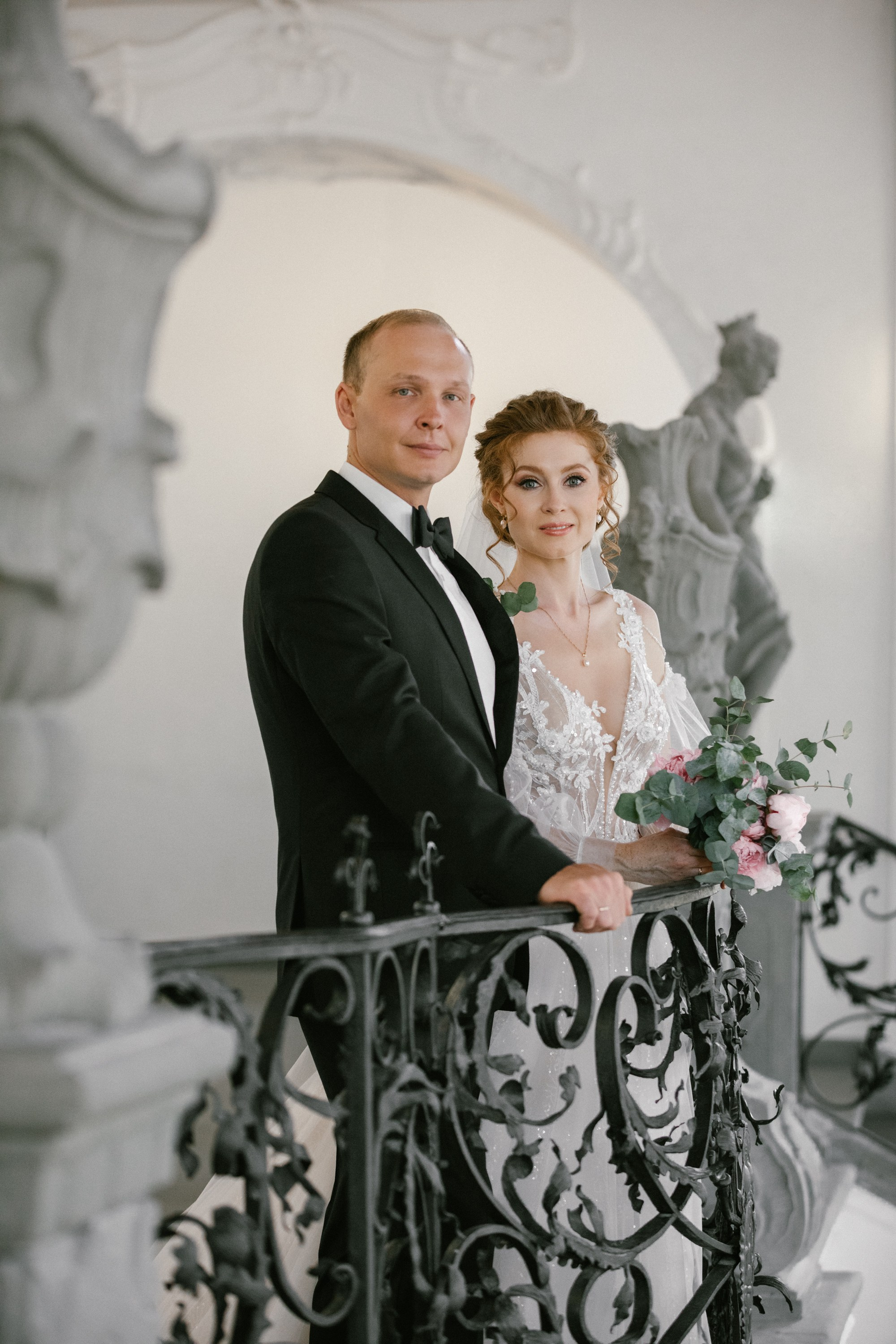 Bride and groom standing together near baroque balcony inside Schloss Meersburg