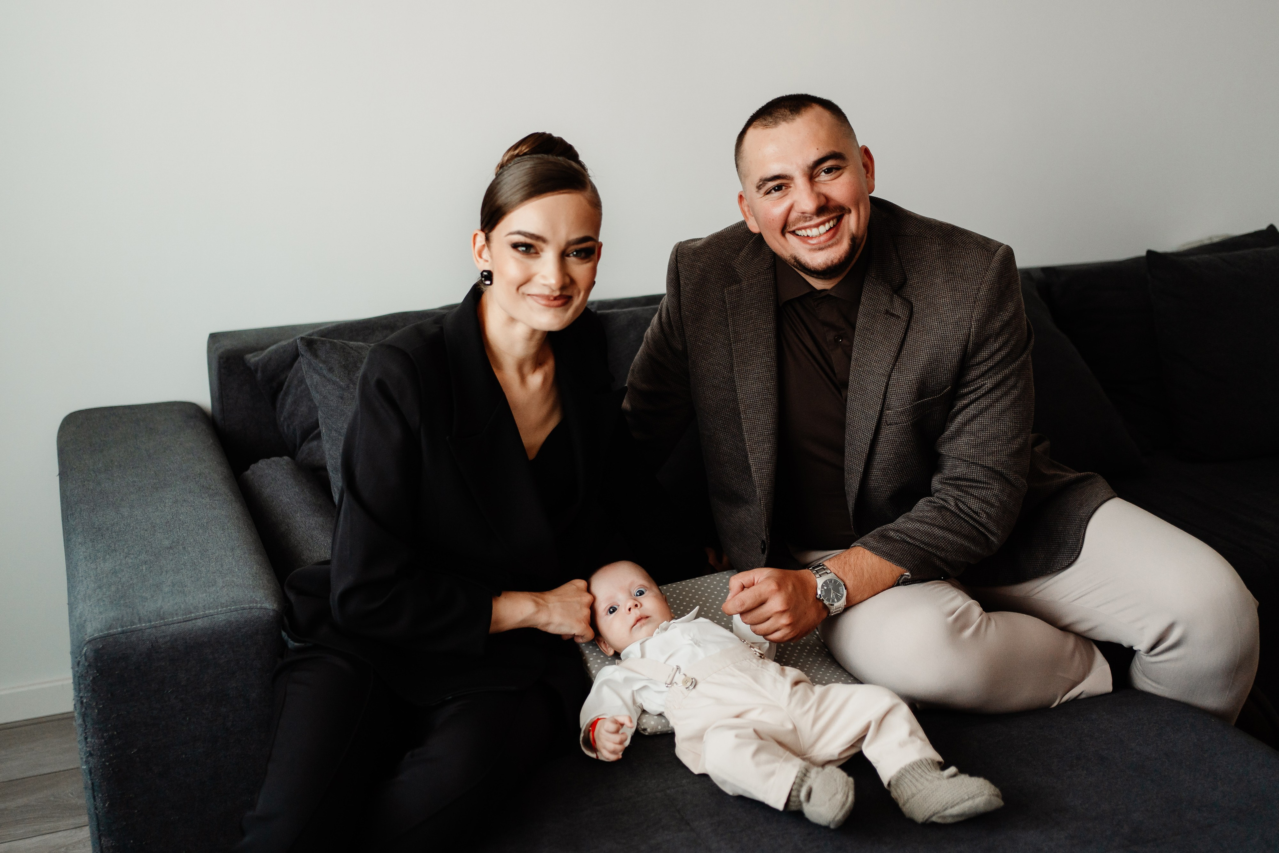 Instantaneu plin de tandrețe dintre părinți și bebeluș în ziua botezului, realizat în Craiova. Fotografie profesională de botez, capturând emoțiile autentice ale familiei într-un decor luminos și cald