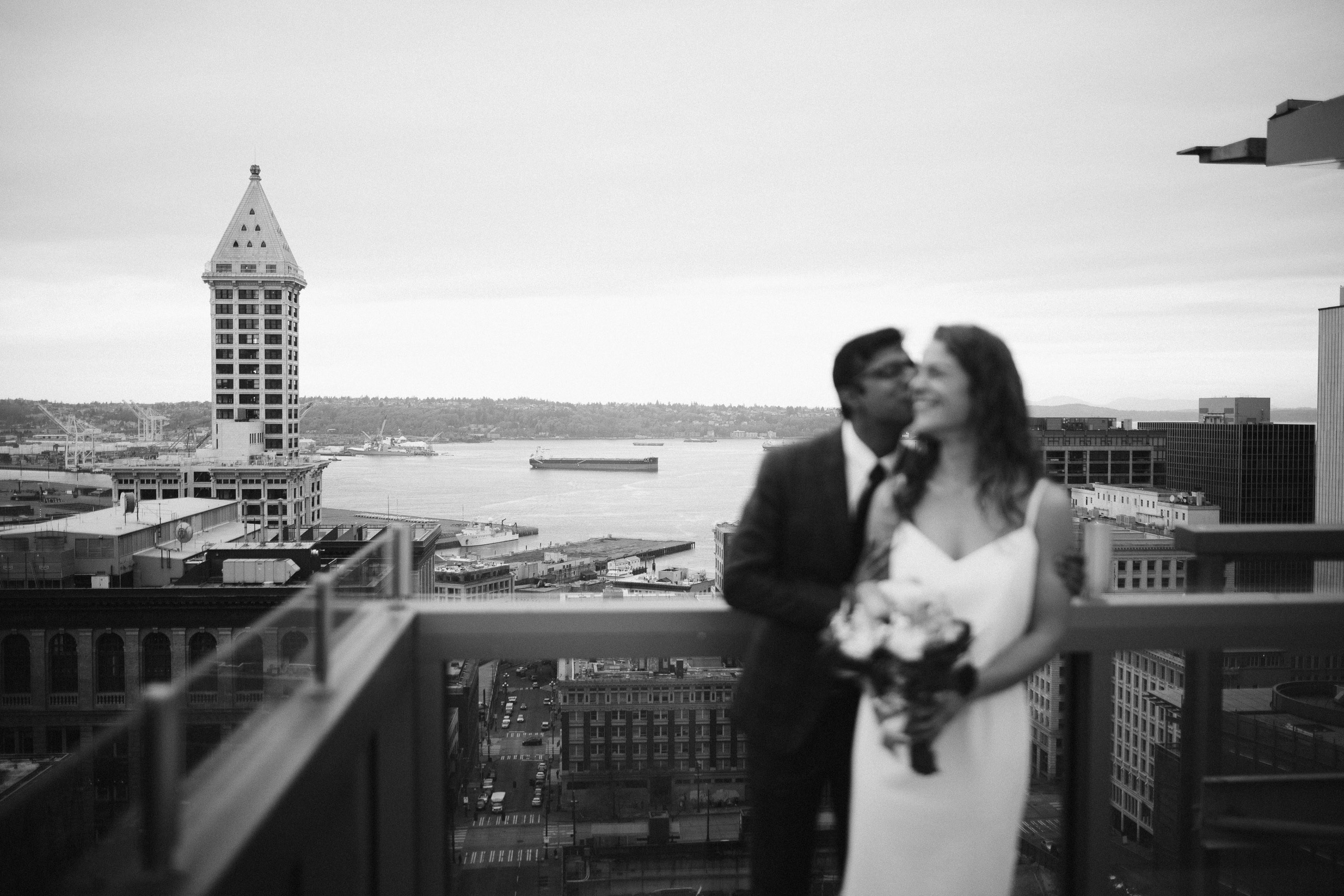 Bride and groom on rooftop with city view, black and white photo