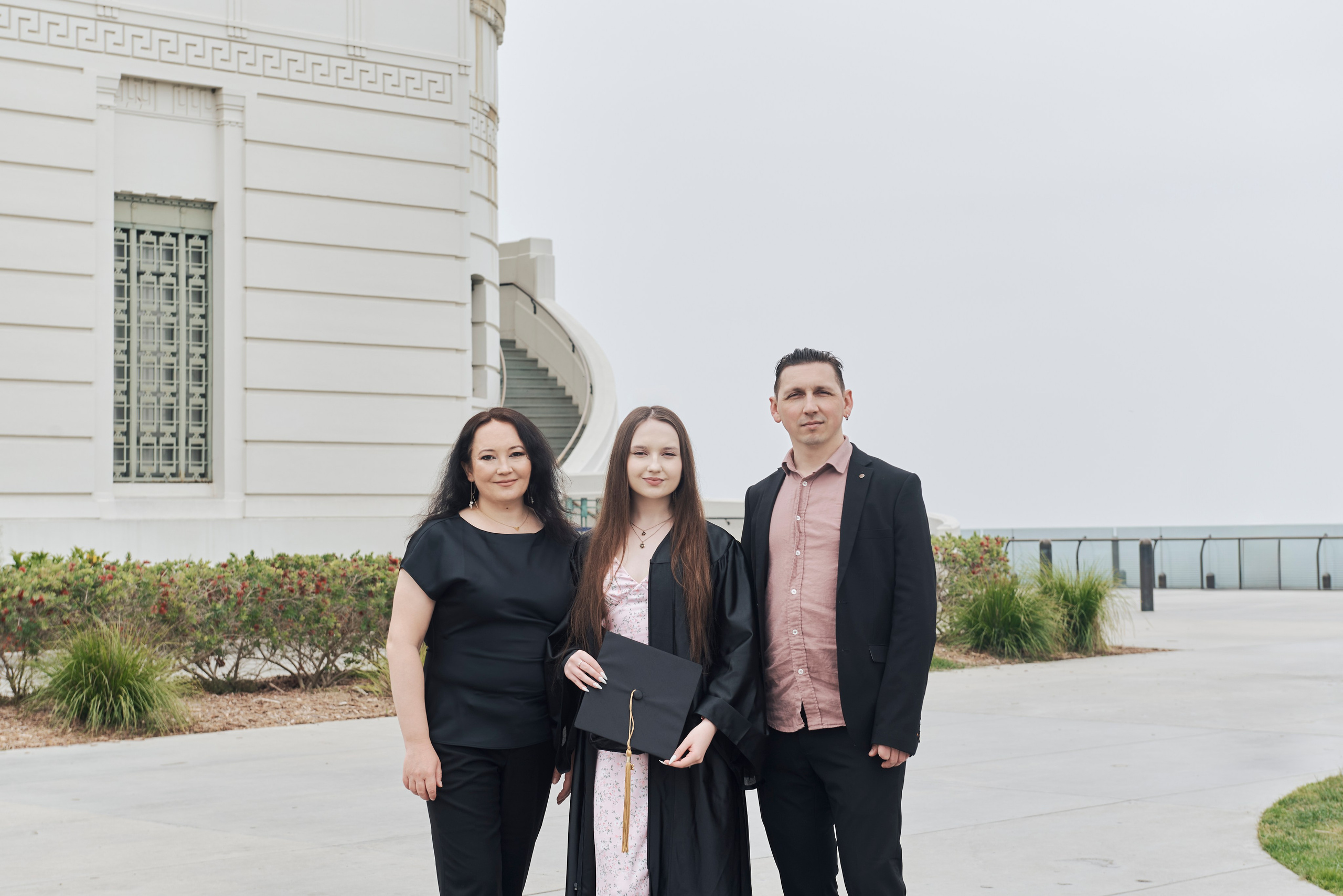 Candid shot of a graduate smiling while walking through a beautiful Los Angeles garden