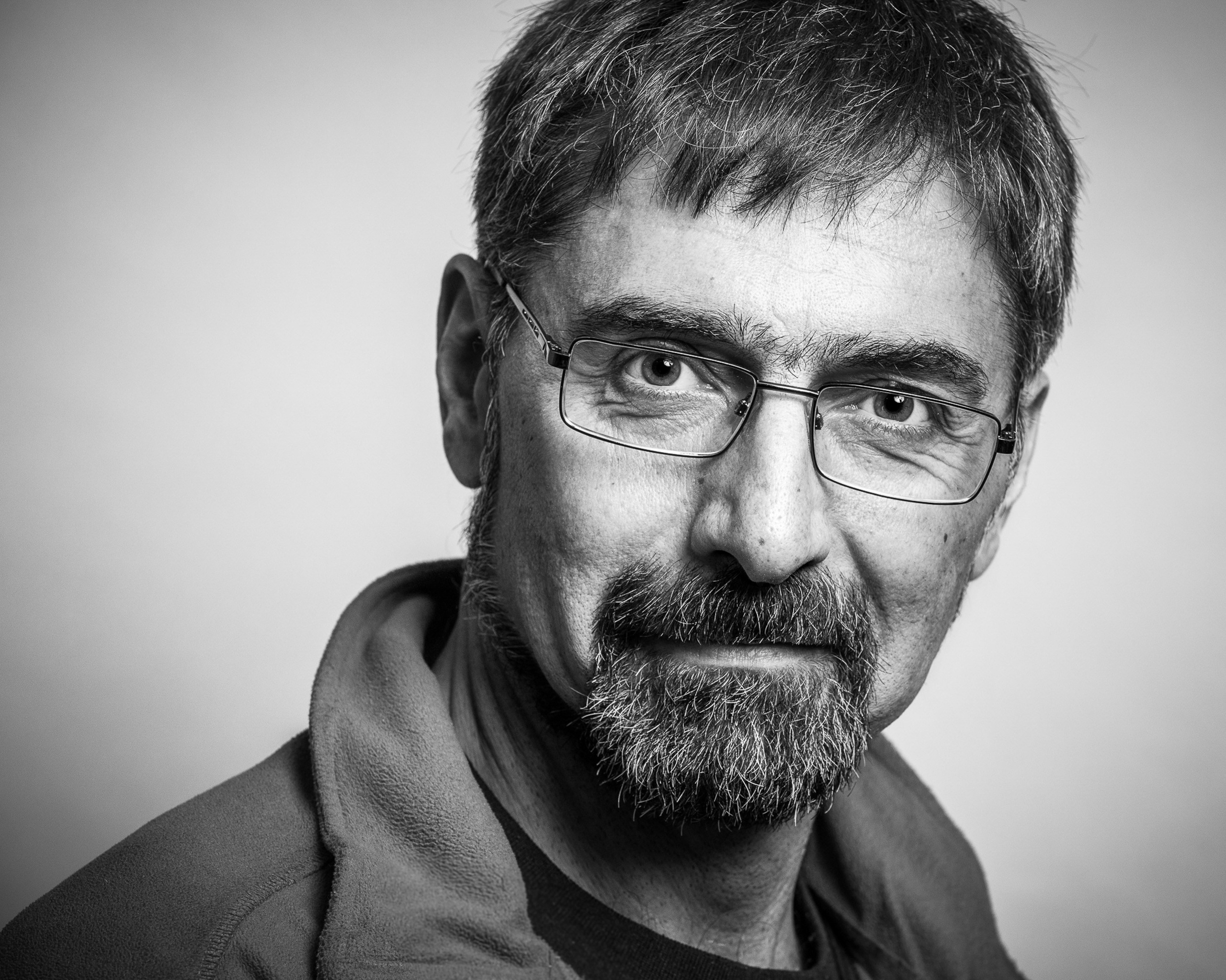 Black and white portrait of a man against a grey studio background - photographer Andrey Dunin