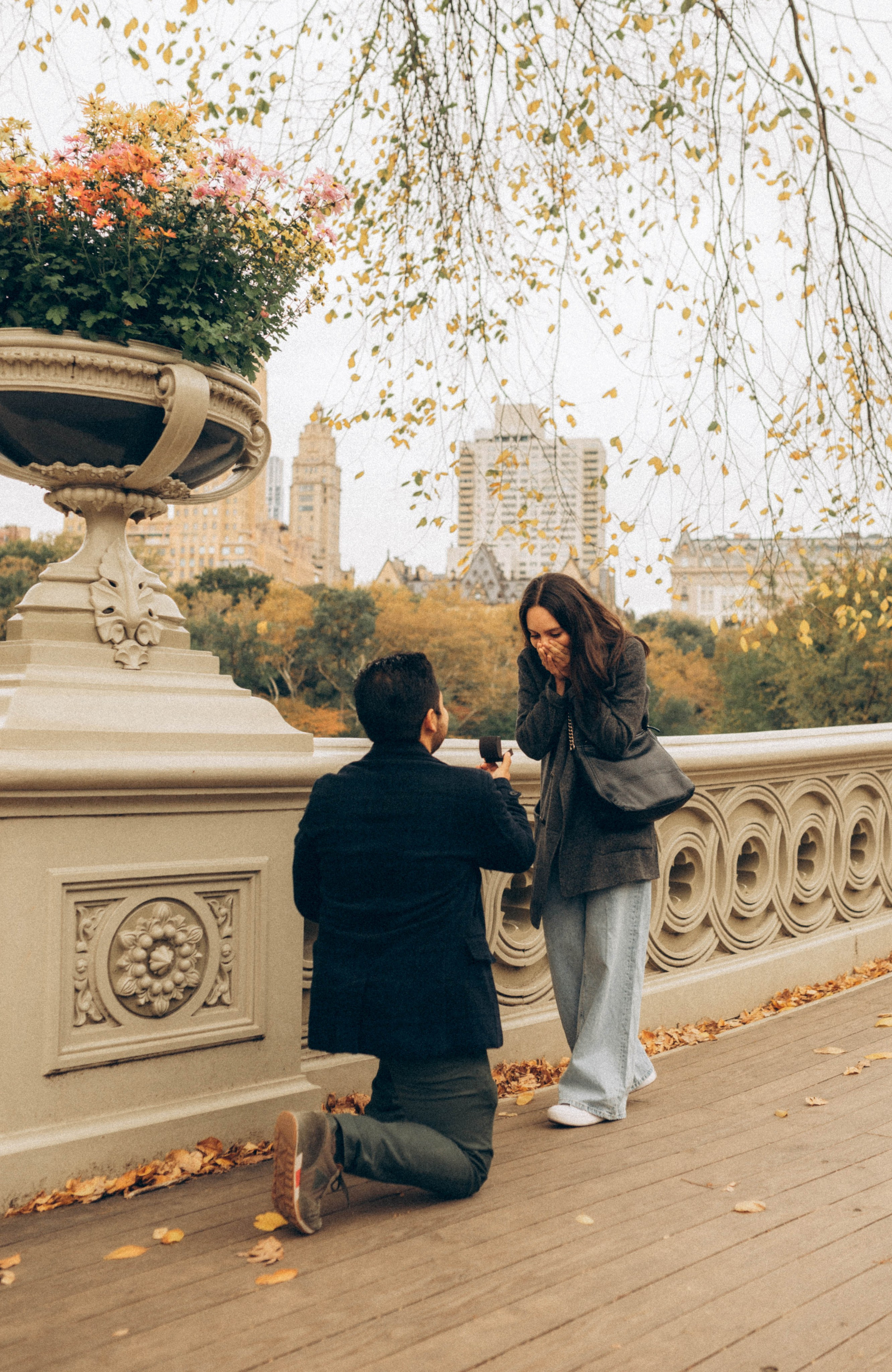 Emotional couple hugging on Brooklyn Bridge steps.