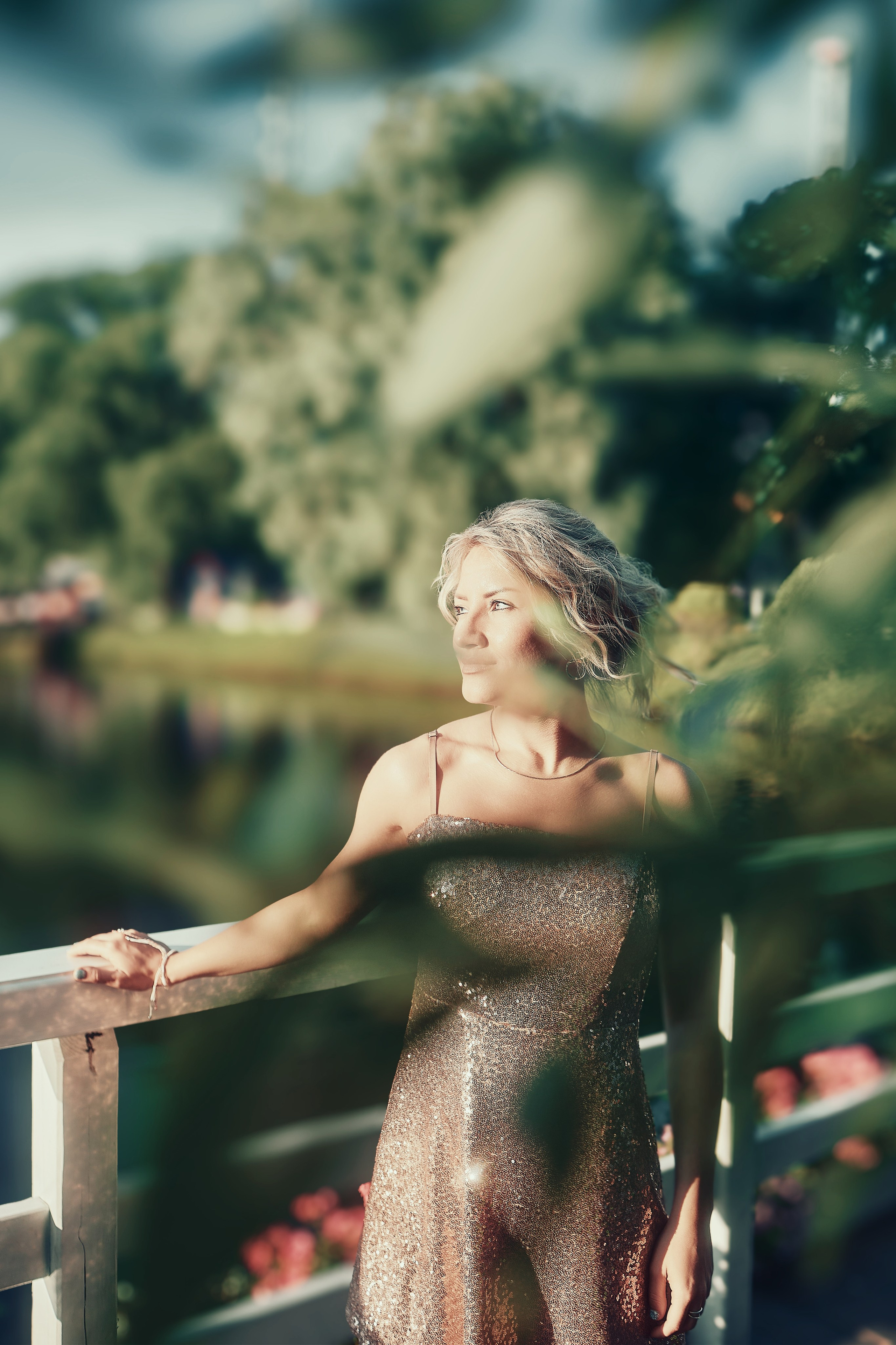 Уличная фотосесия девушка в блестящем платье у дерева