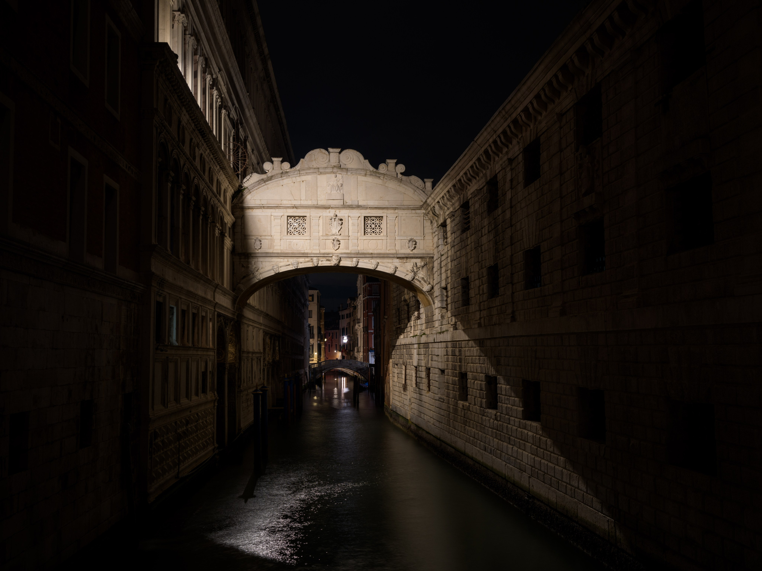 Bridge of Sighs in Venice at night with reflections on the canal