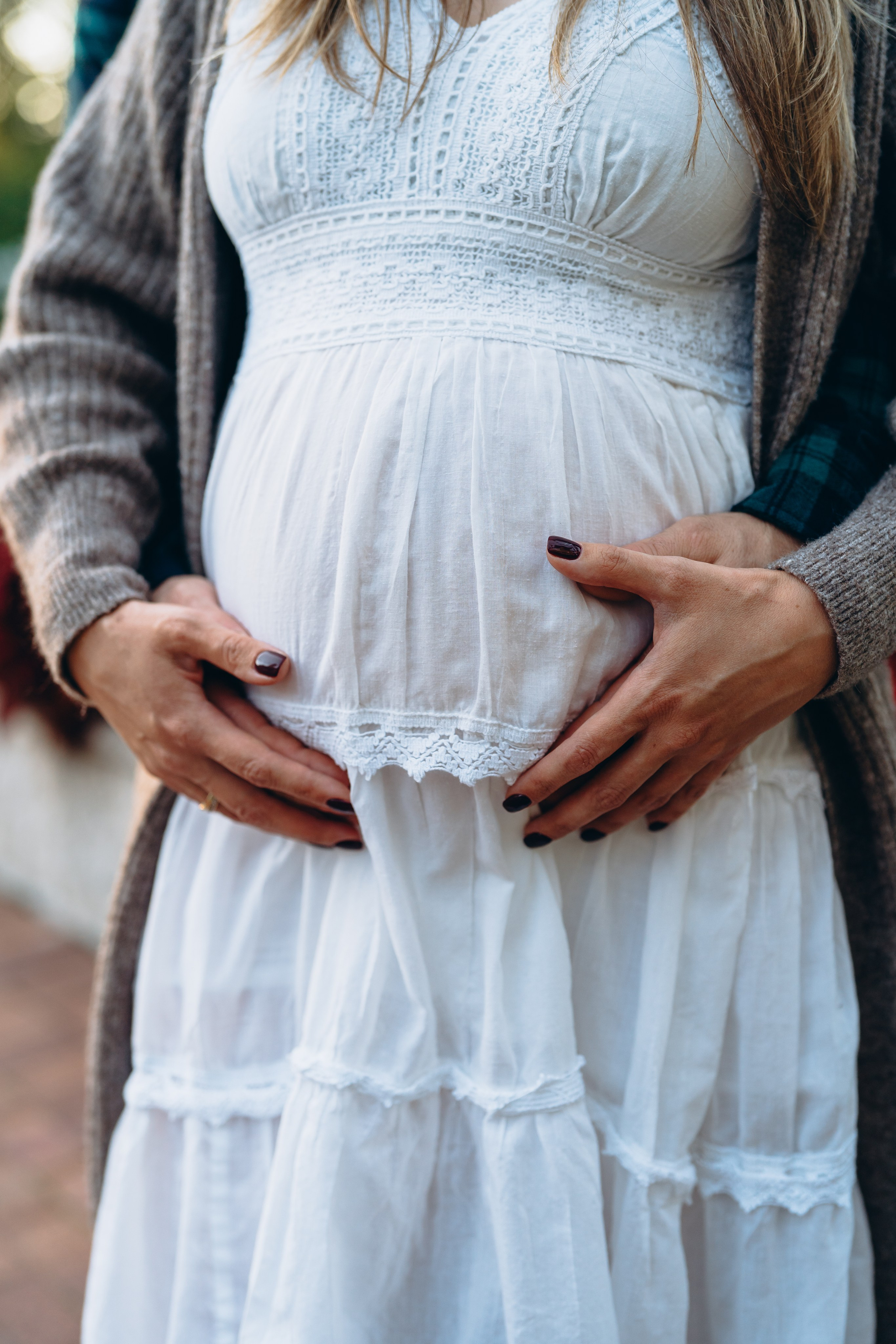 Photo in the style of Pinterest. A woman is pregnant and holds her belly with her hands