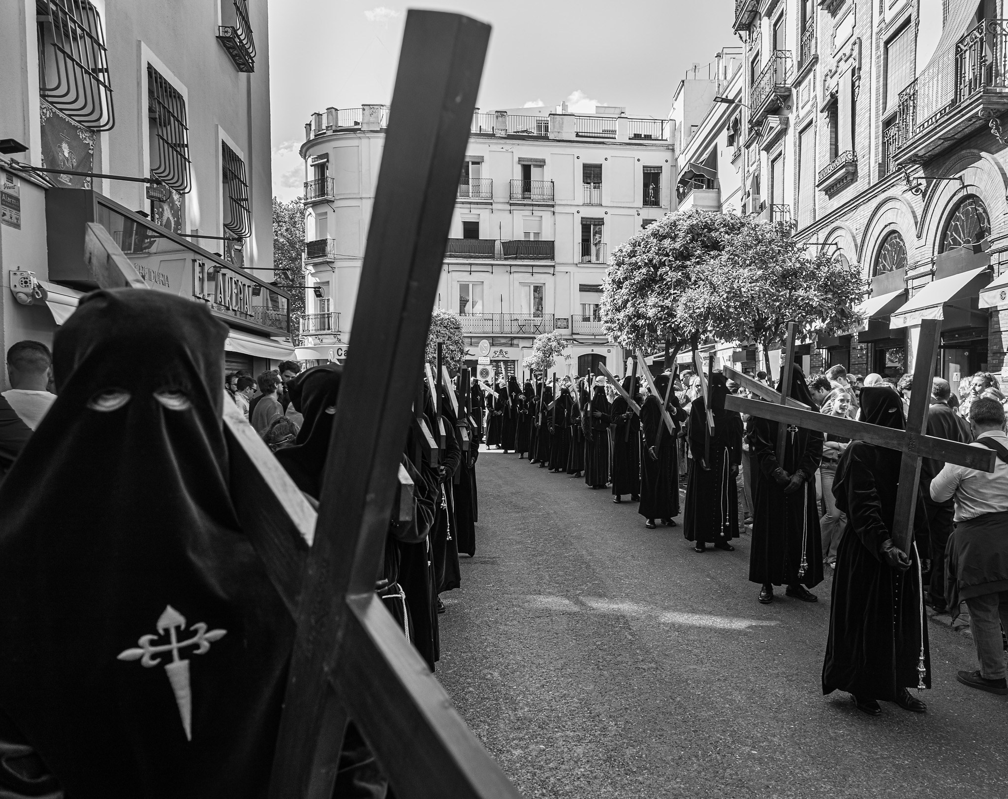 Brotherhood members carrying cross during Semana Santa in Seville, Spain