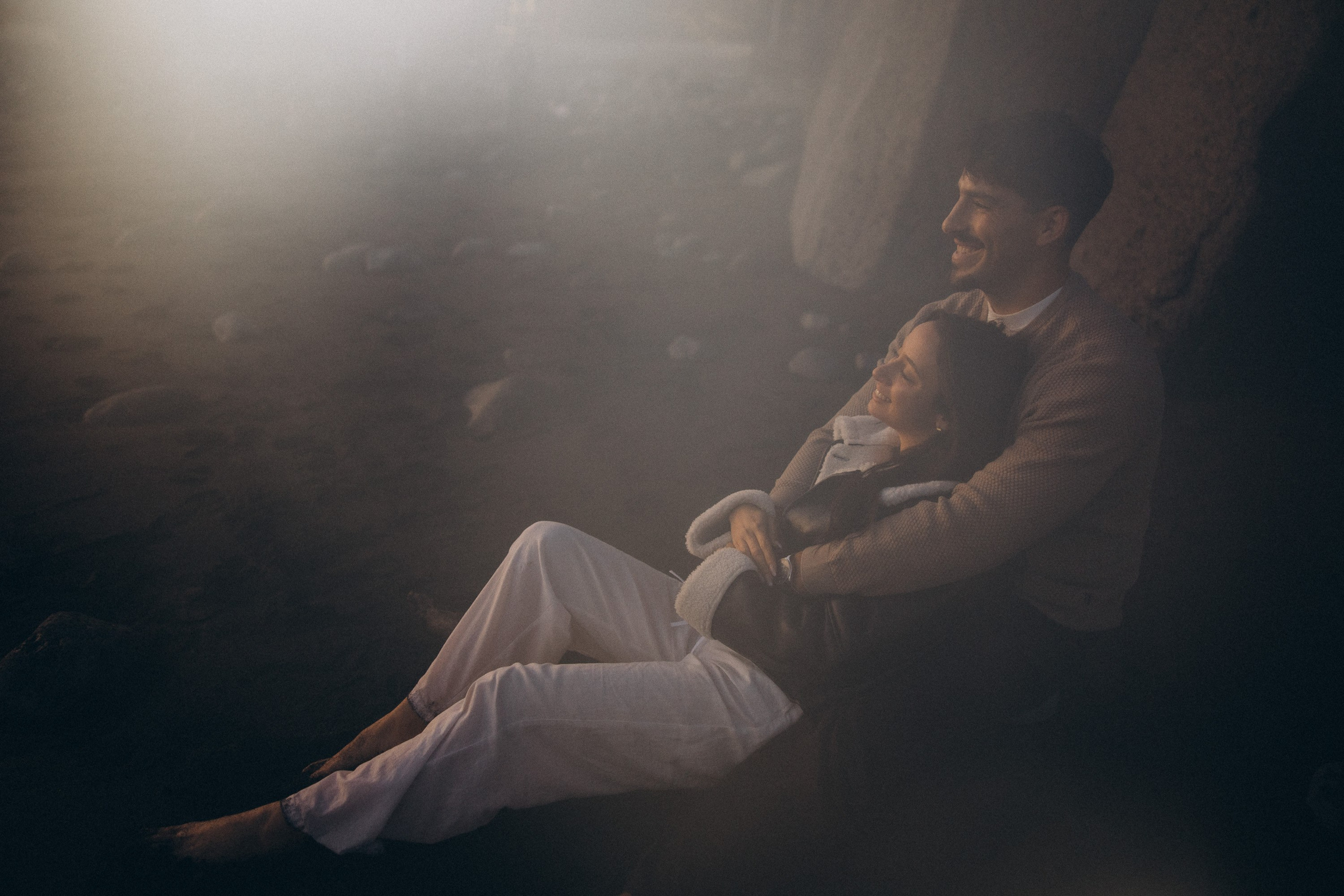 Couple sharing a romantic moment during sunset on Madeira Island, with the ocean and cliffs in the background