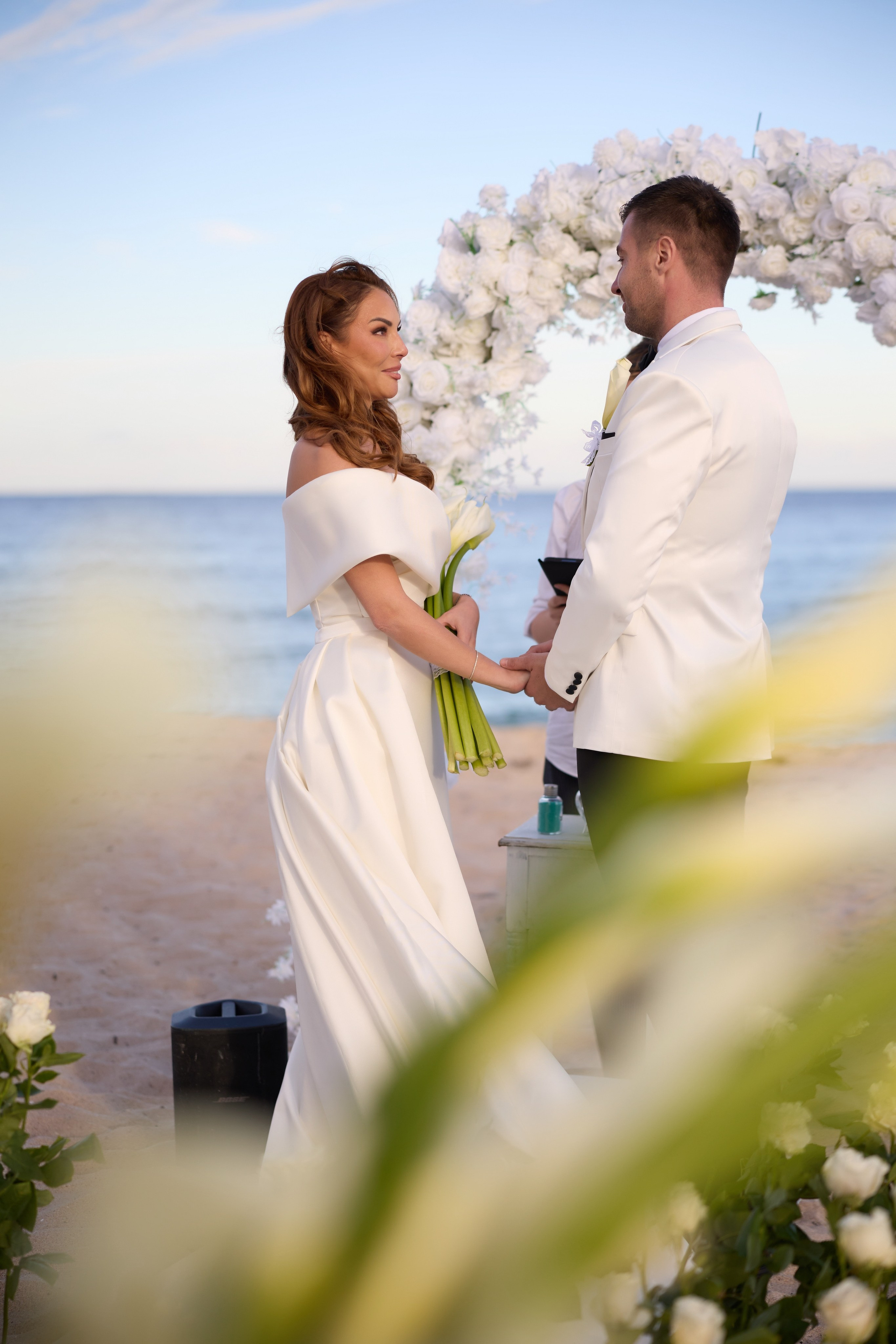 Bride and groom exchanging vows beside the ocean at a beach wedding