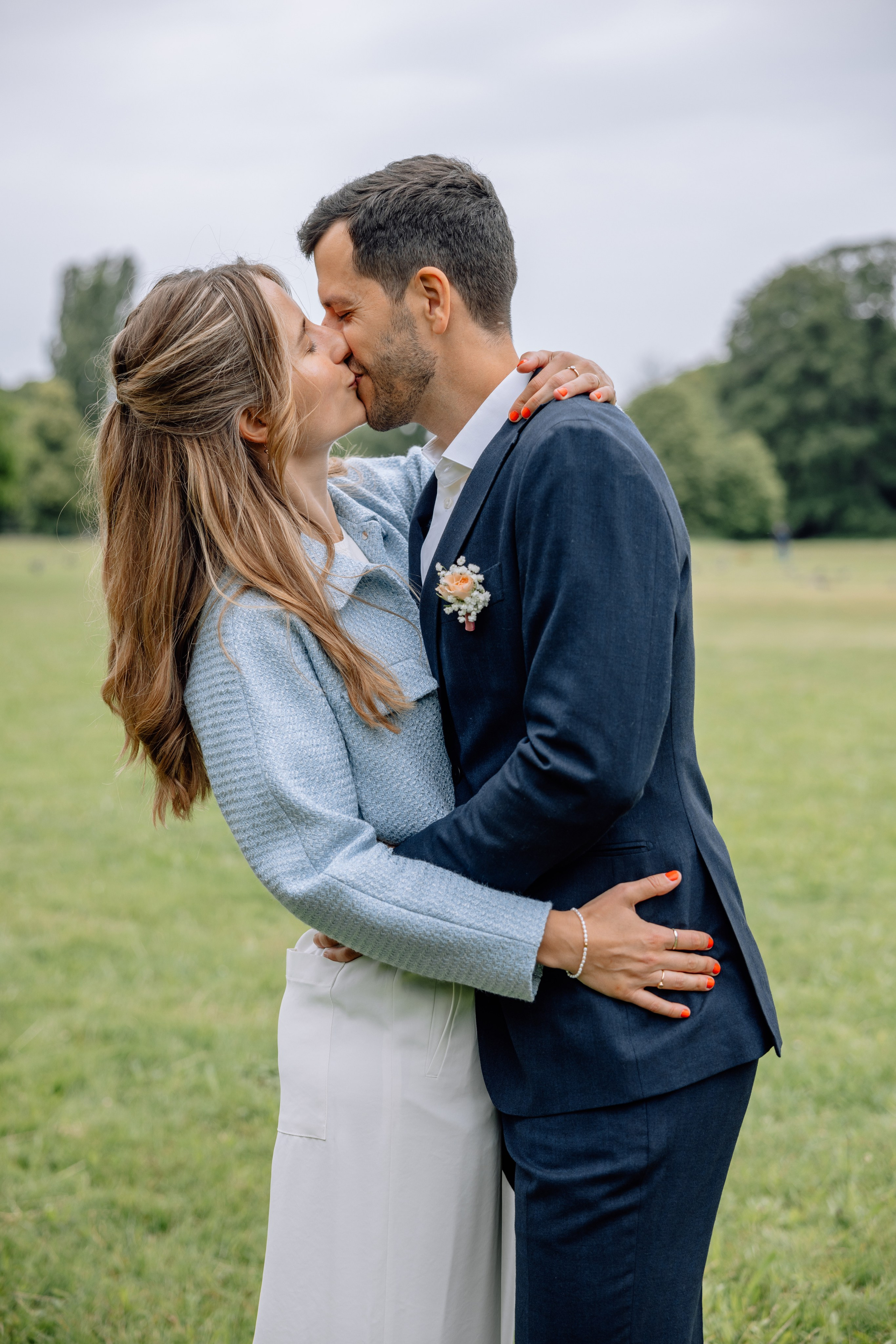 Brautpaar küsst sich beim Spielen – natürliche Emotion im Englischen Garten, nach dem Standesamt Schwabing