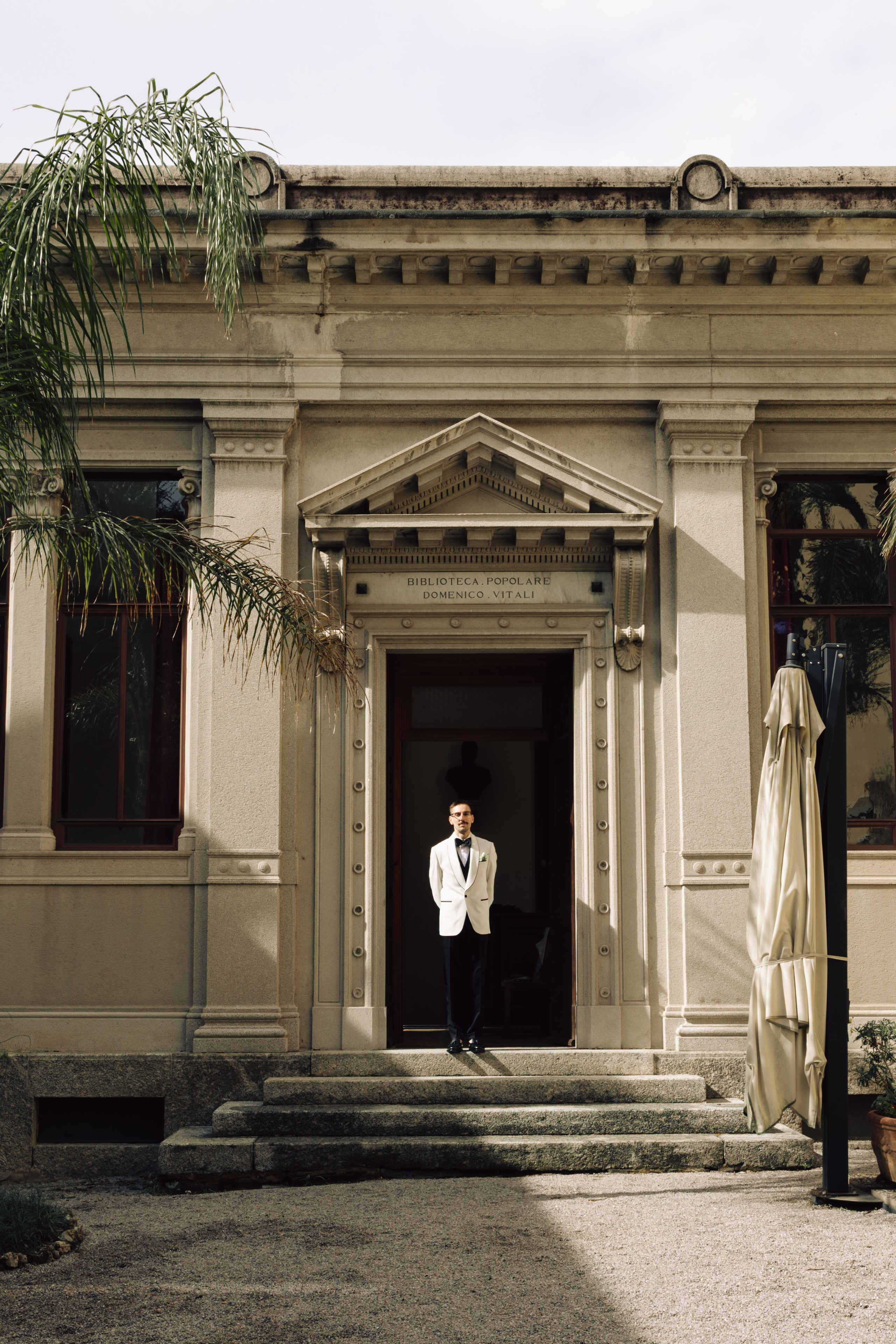 Groom standing in front of a historic villa before his wedding in Bellagio, Lake Como