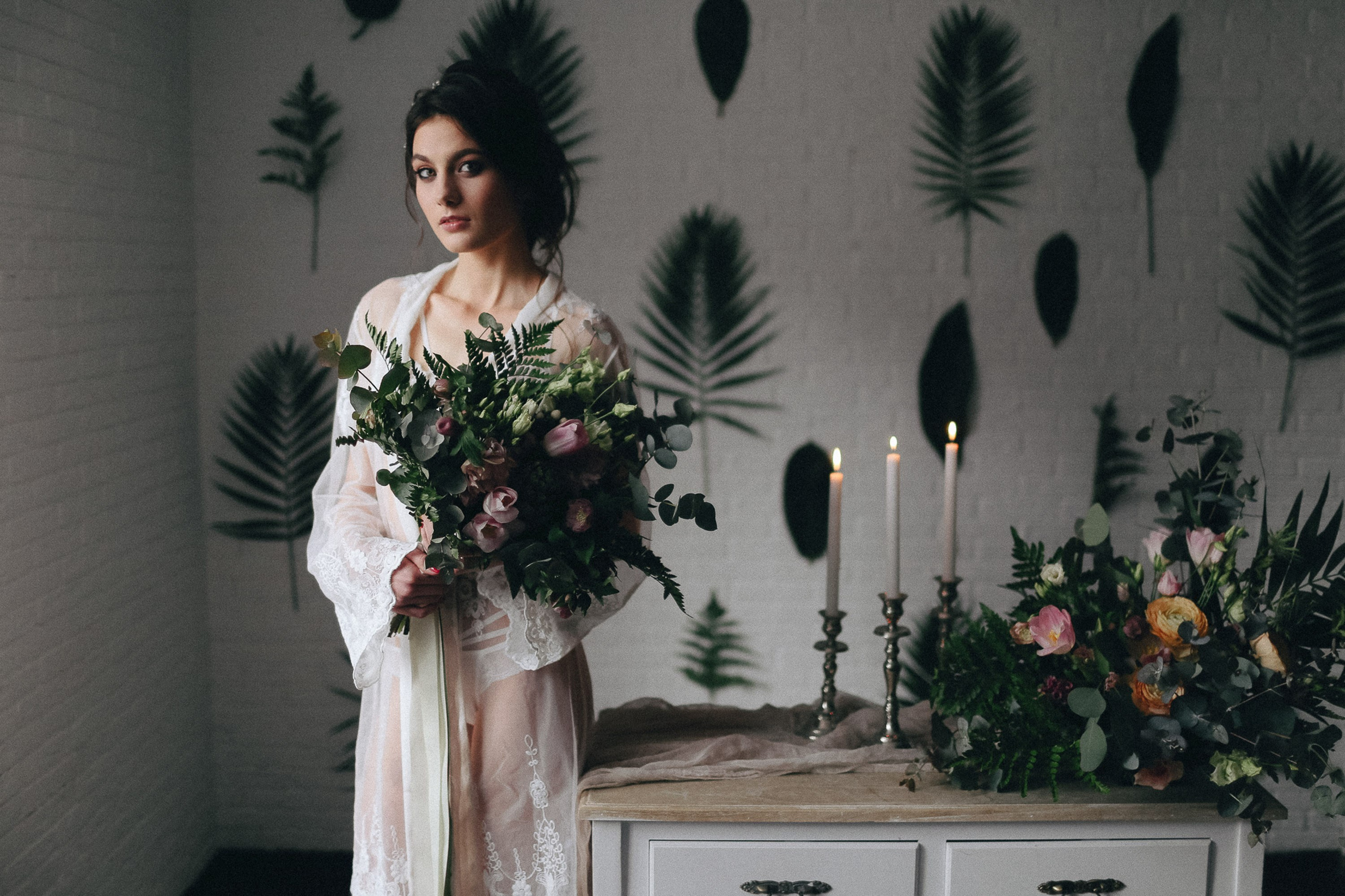 Bride with bouquet standing indoors, wedding preparation