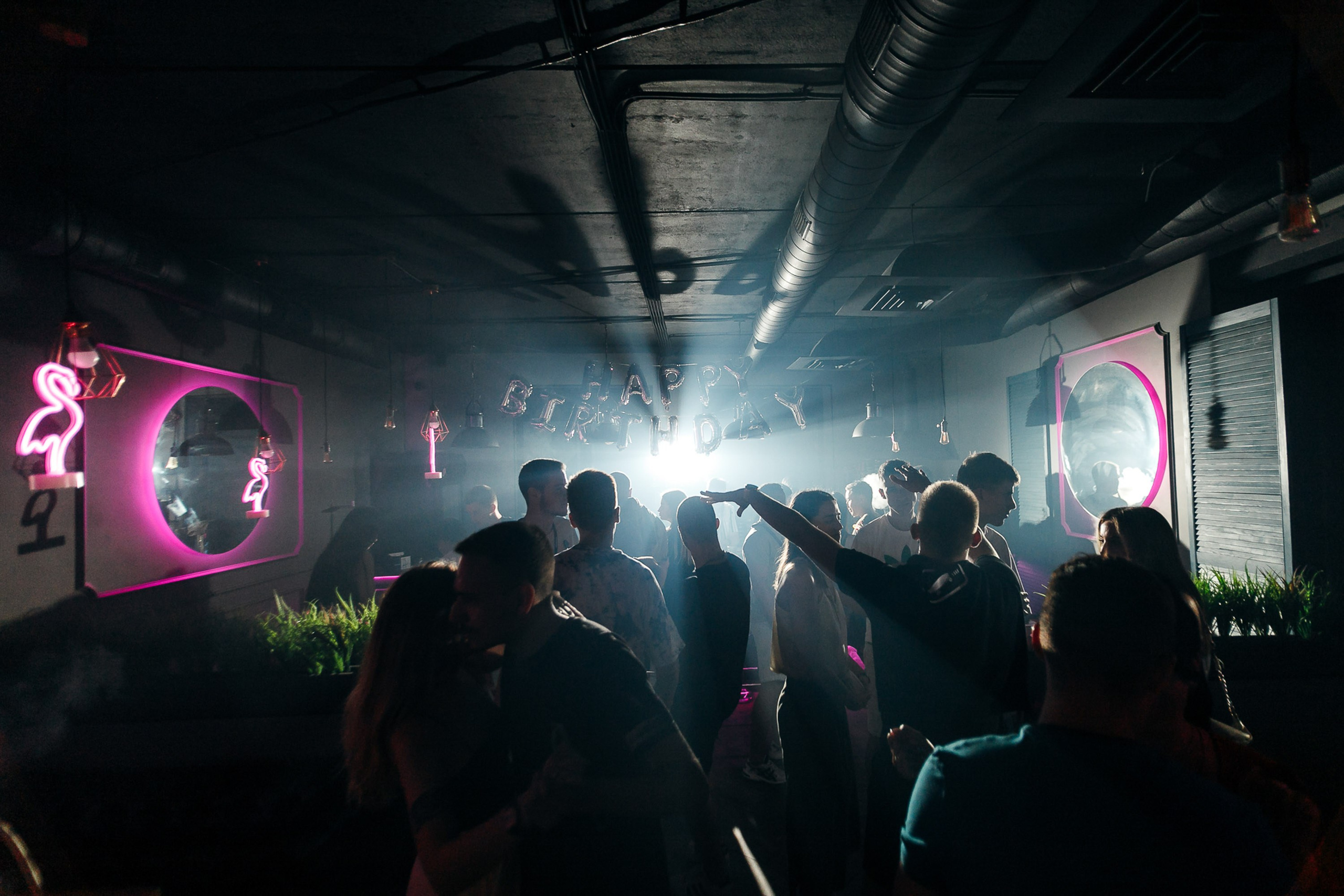 Crowd dancing under lights at nightclub, party atmosphere