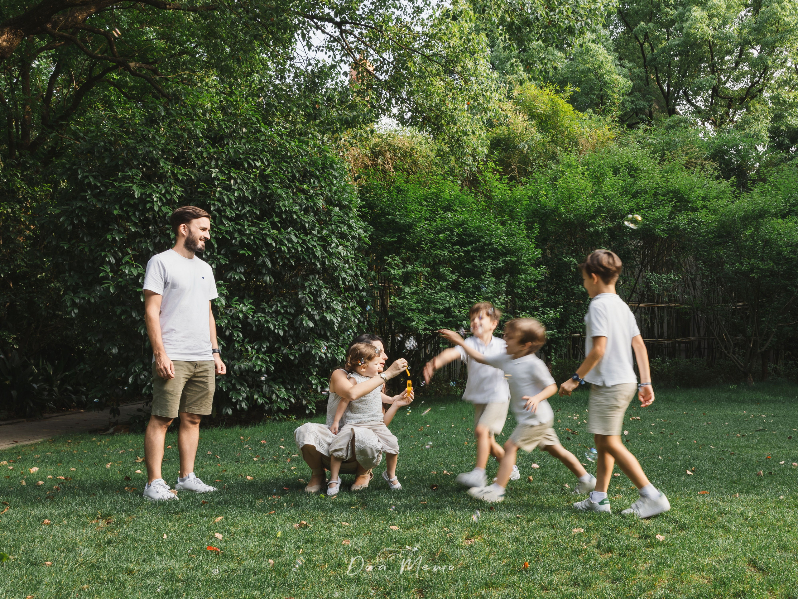 Whole family blowing bubbles together | A Shanghai family photography session — parents and four kids playing with bubbles together