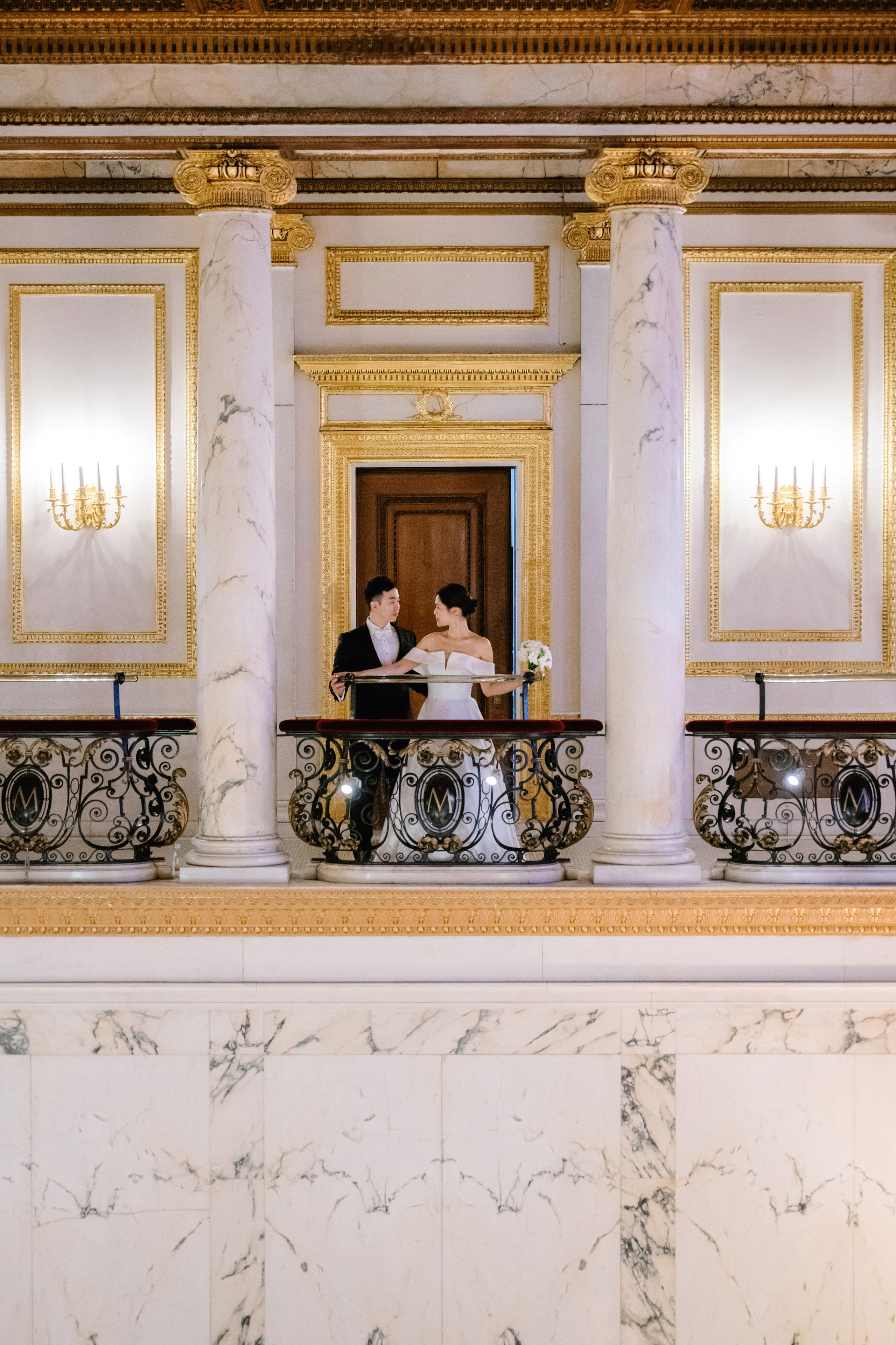 a bride and groom are sitting on the balcony of the state house