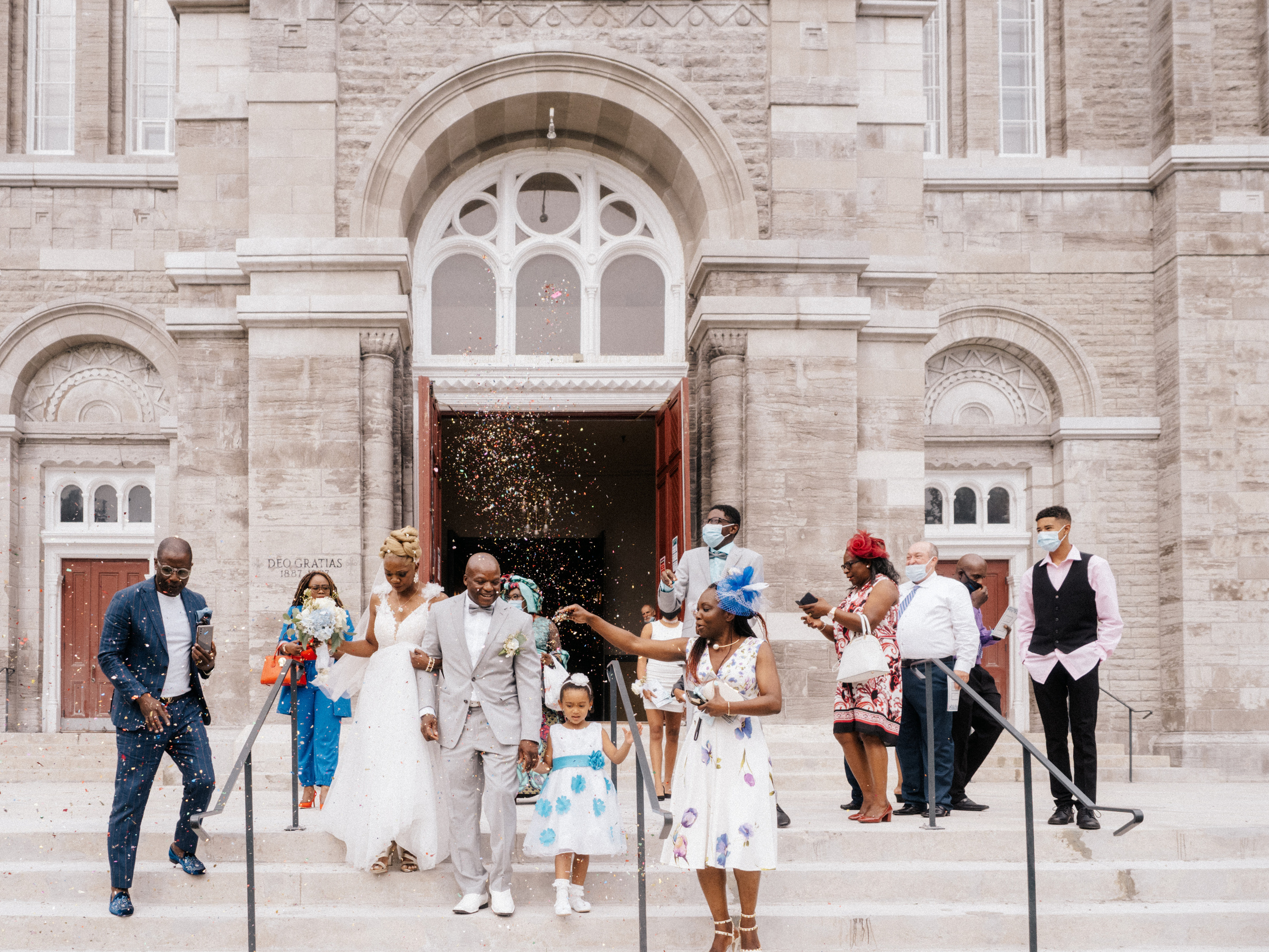 Couple in wedding attire exiting church in Laval, Canada.