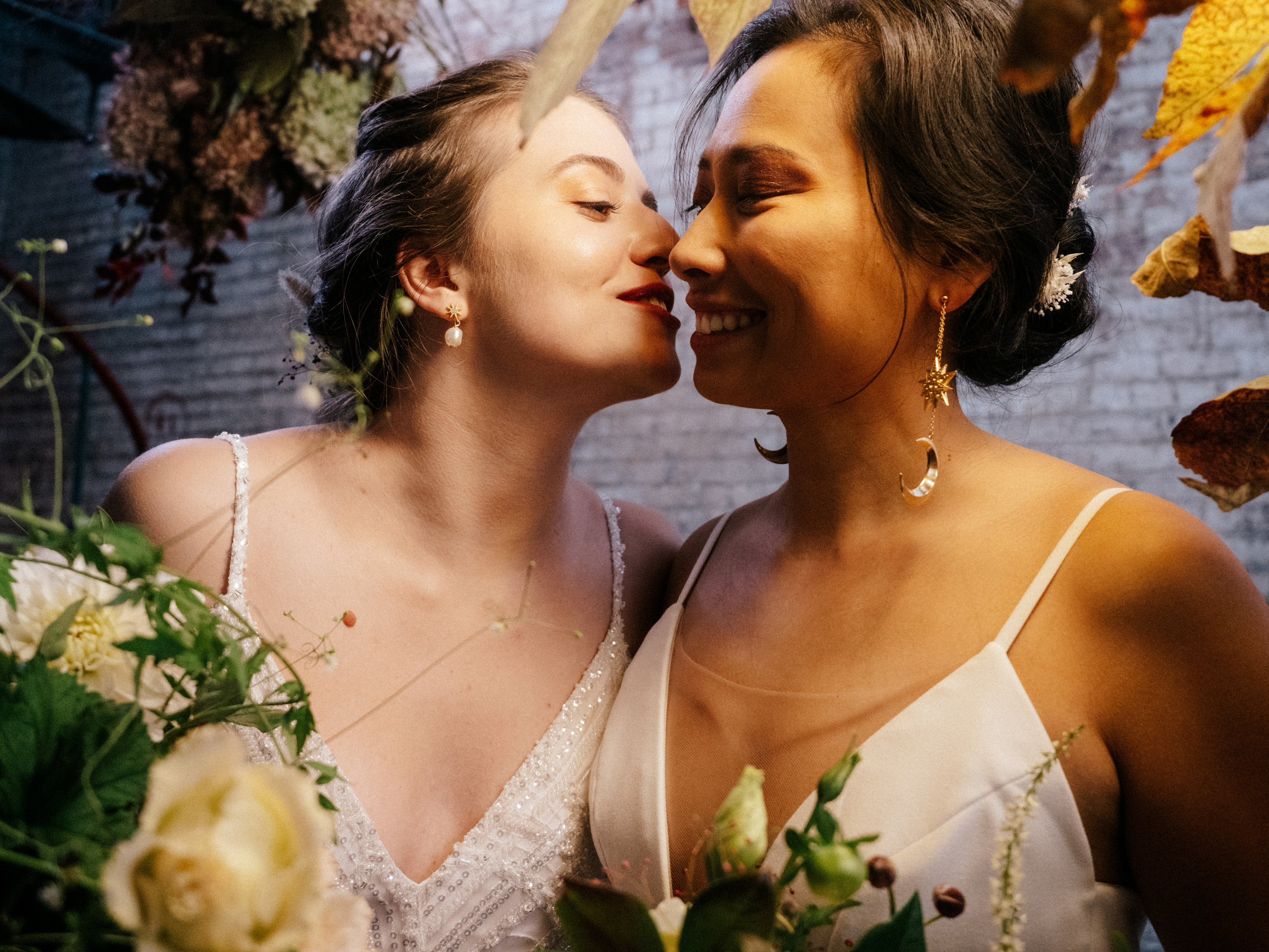 Lesbian couple giving a kiss on the cheek in urban environment.