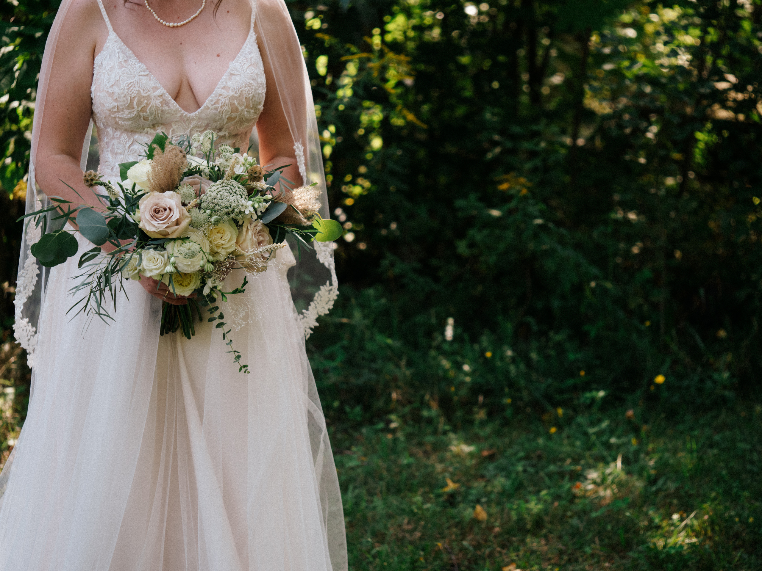 Bride holding bouquet of flowers made by Kyoto Fleurs on Domaine St-Simon site in Saint-Simon-de-Bagot, Quebec.
