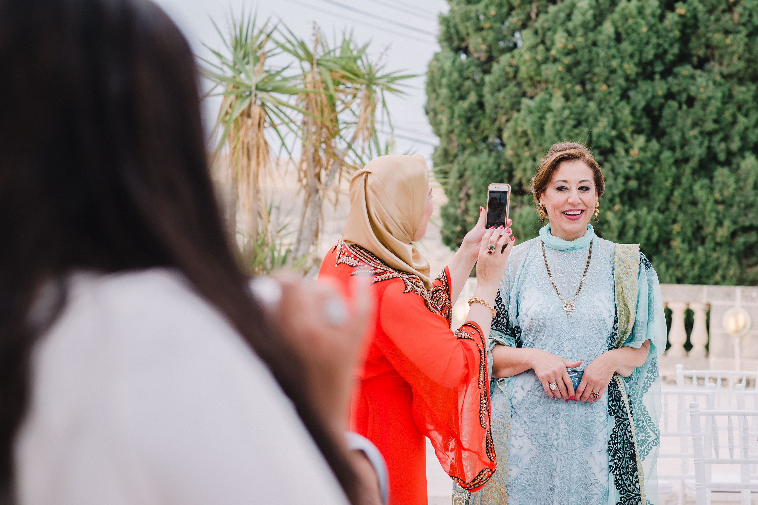 lady in a red dress making photos of attractive women on arabian wedding 