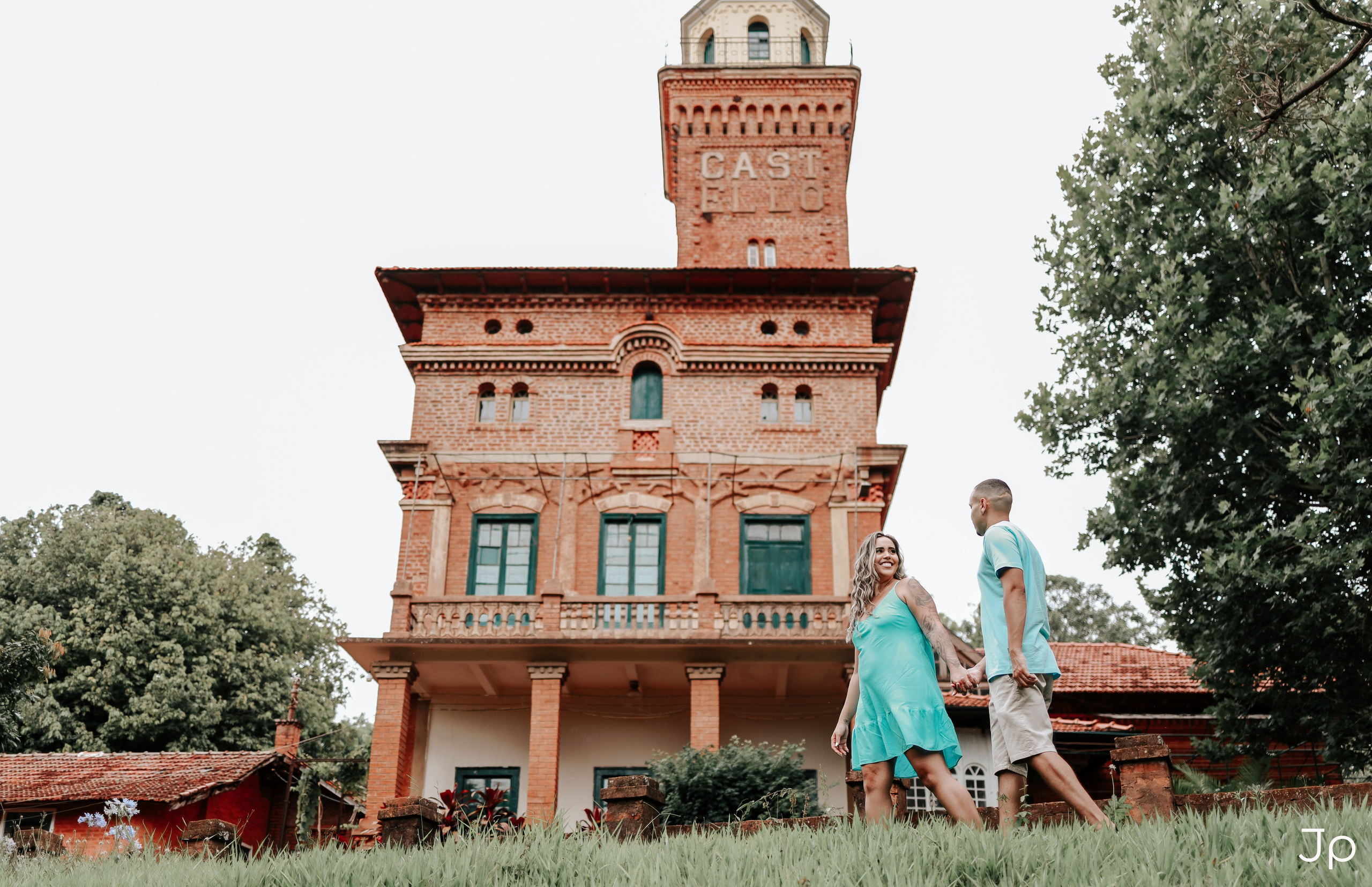 Fotógrafo de pré-wedding em Pederneiras registra casal sorridente em frente ao castelinho histórico.