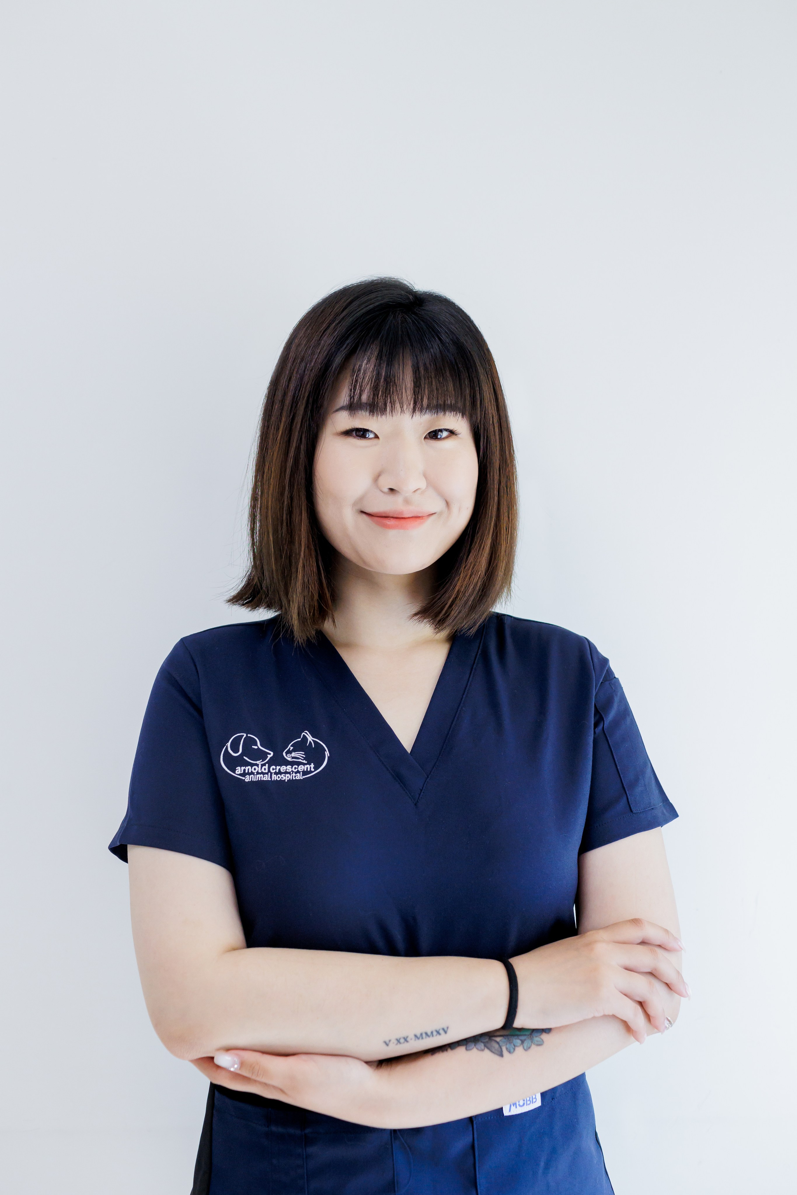 headshot of Asian vet tech with black hair posing in animal hospital 