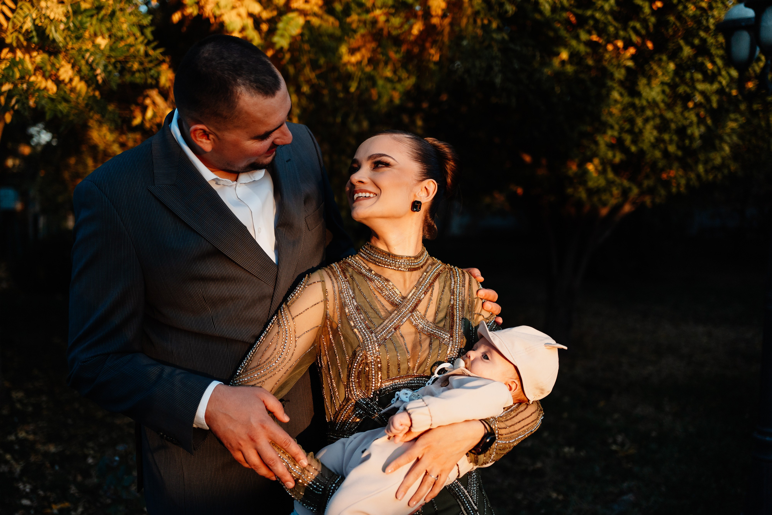 Instantaneu plin de tandrețe dintre părinți și bebeluș în ziua botezului, realizat în Craiova. Fotografie profesională de botez, capturând emoțiile autentice ale familiei într-un decor luminos și cald