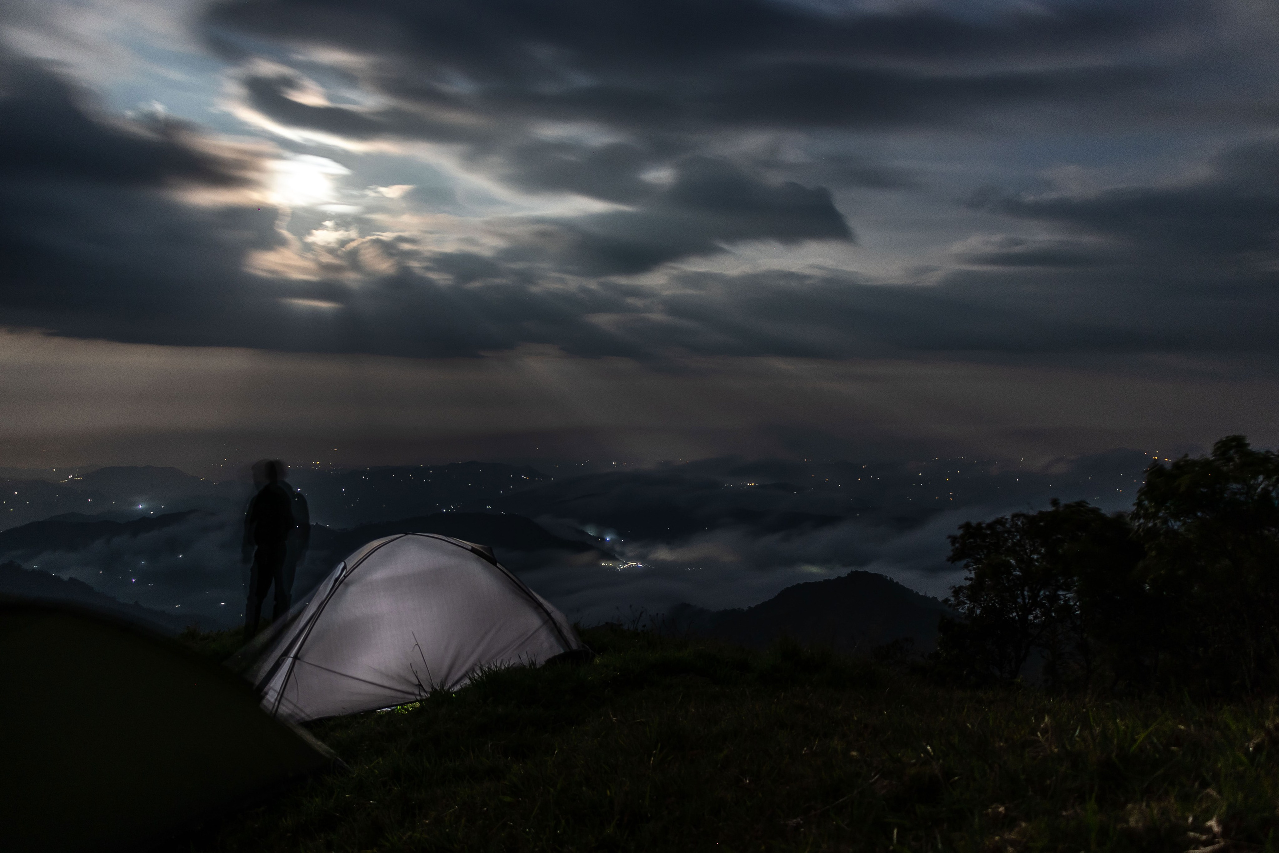Persona acampando bajo la luz de la luna 