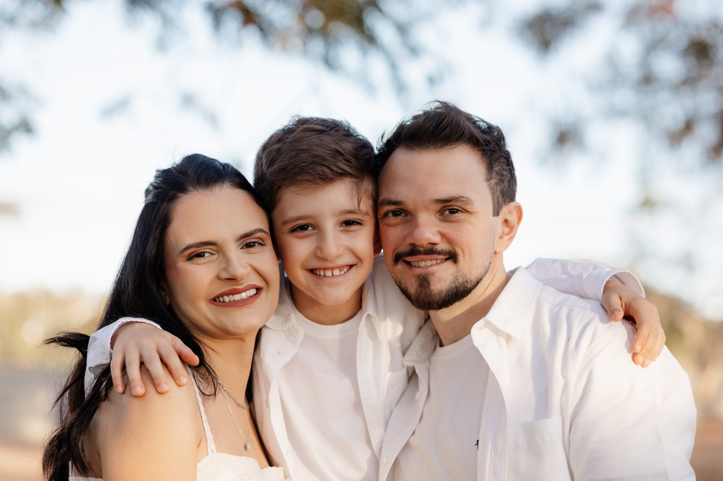 Gestante, pai e filho mais velho juntos no parque.