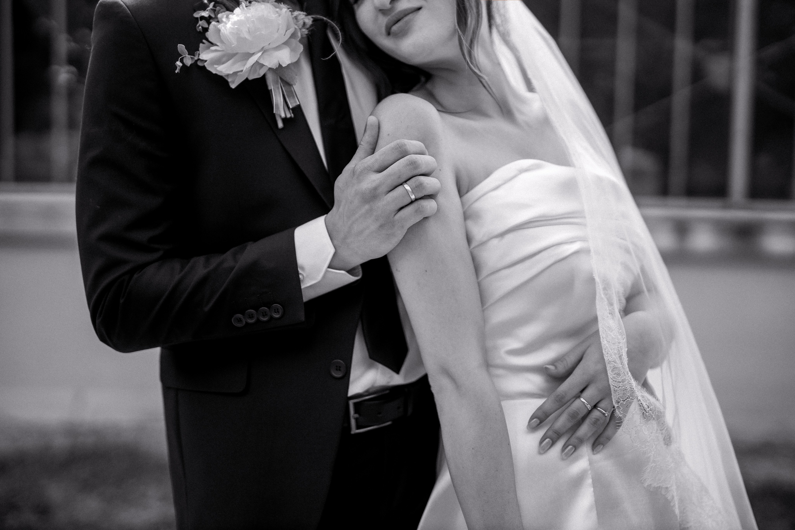 detalj ruke mladozenje kako dodiruje mladu po ramenu