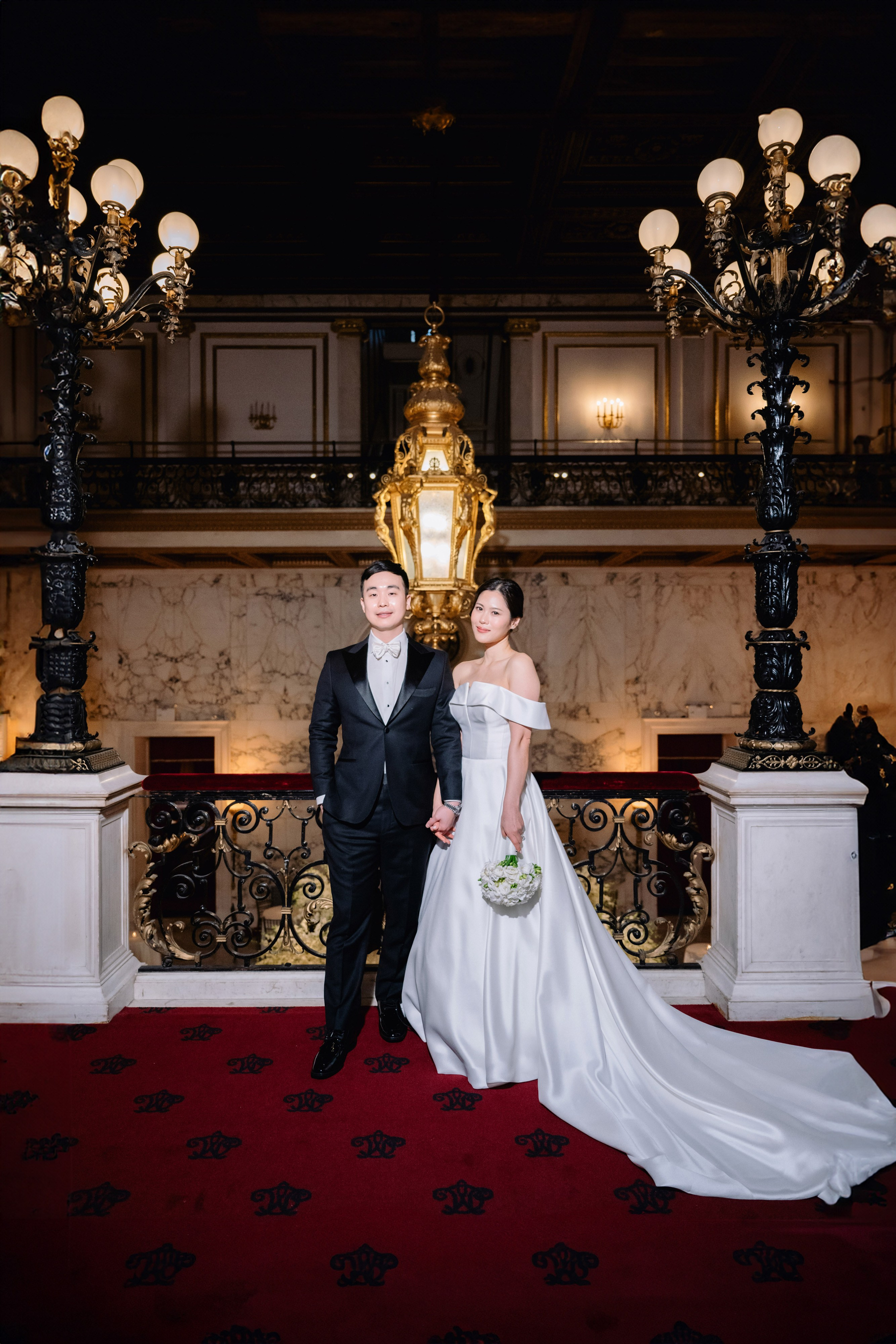 a bride and groom pose for a photo in the lobby of the hotel