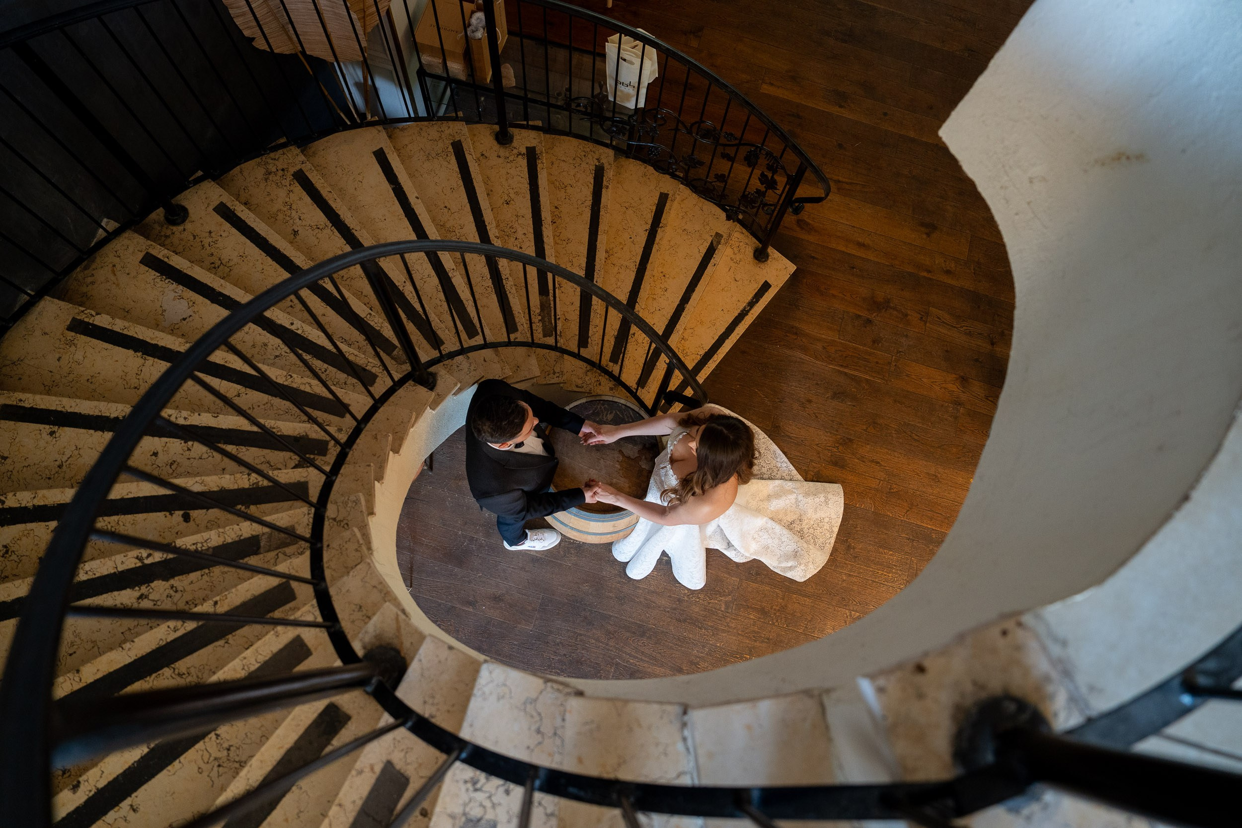 High angle view of bride Tzipi and groom Ron holding hands by a wine barrel at Amphorae Winery