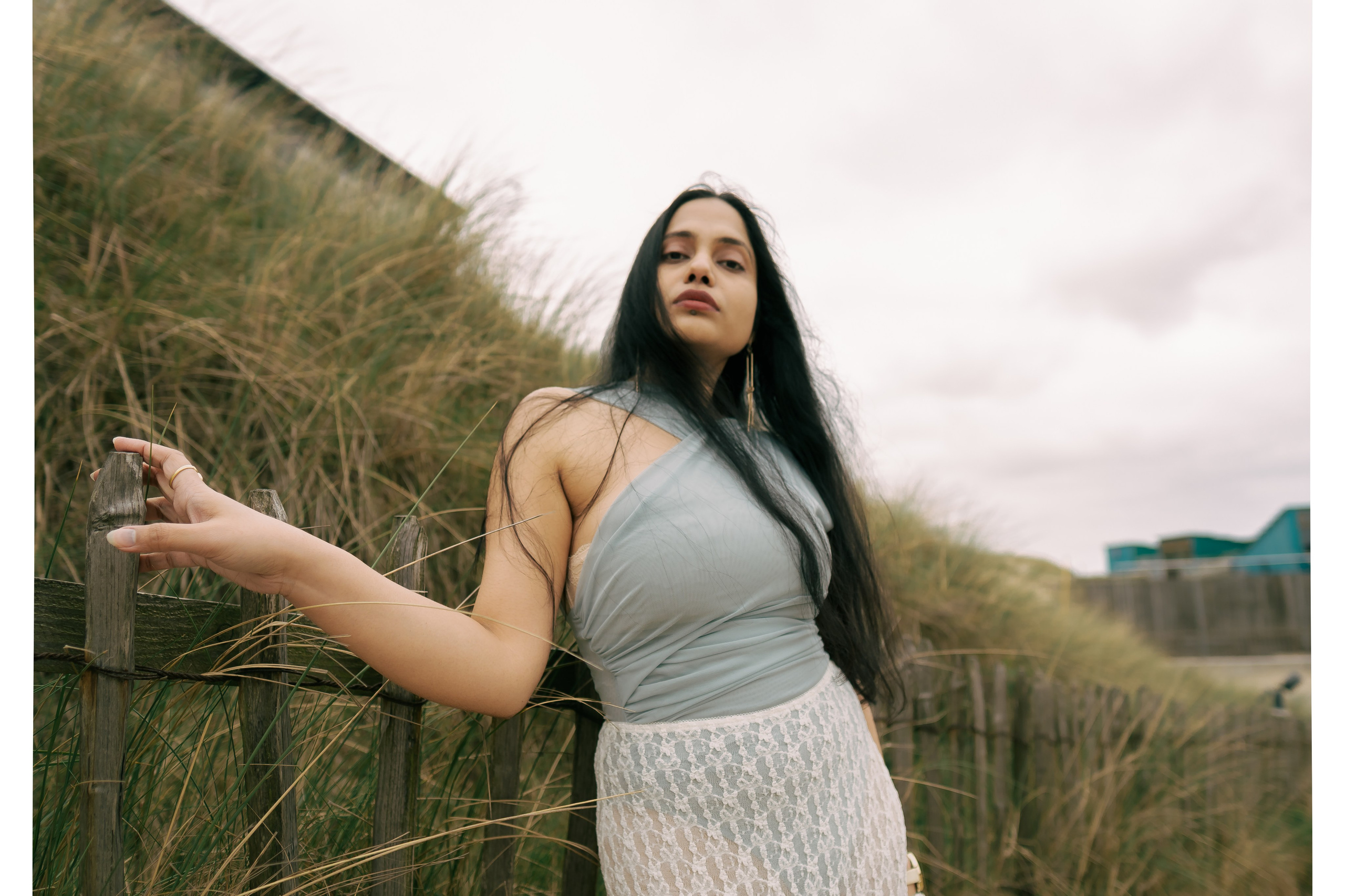 Fashion photoshoot in dunes with lace skirt and lace blue top