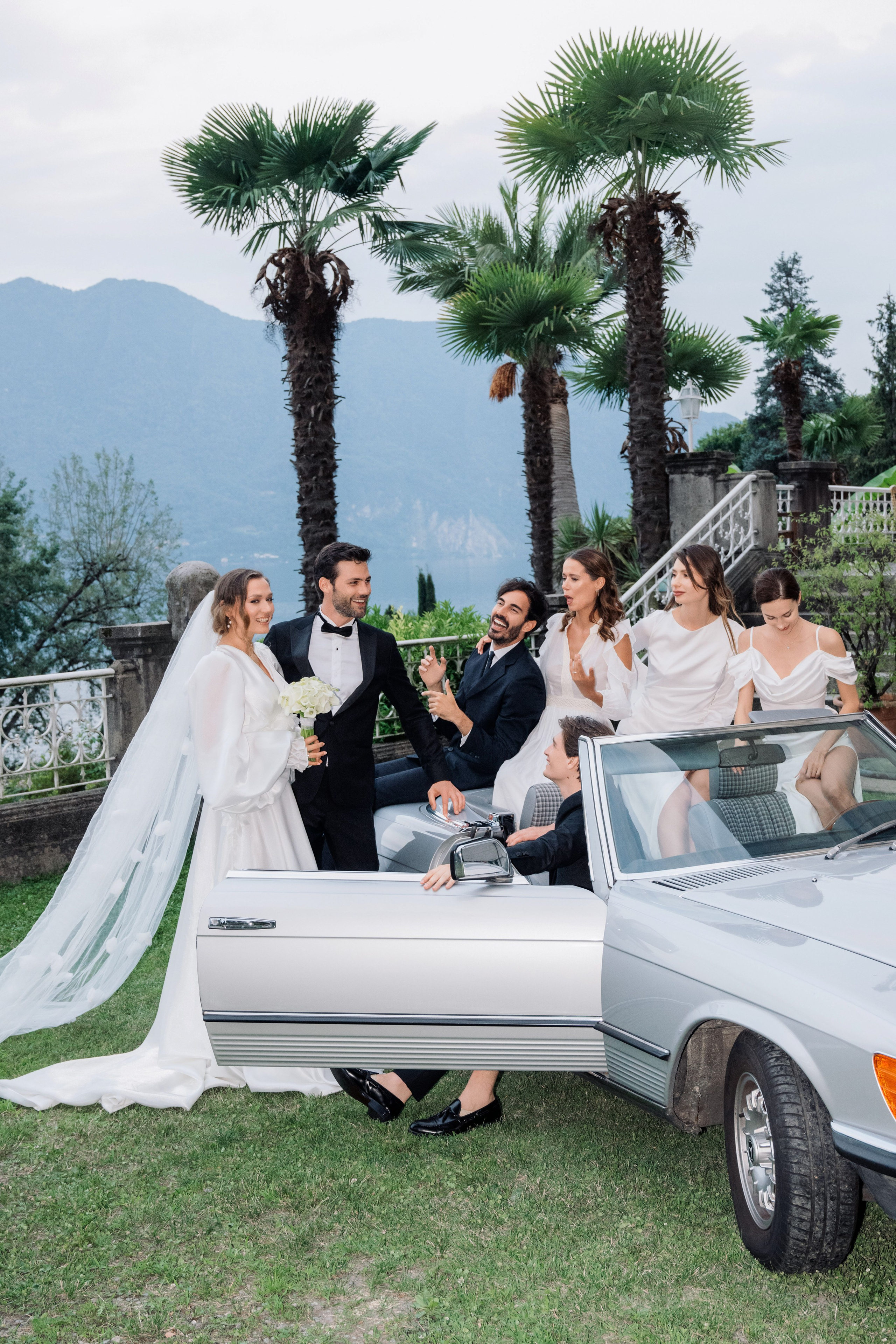 a bride and groom in a convertible car