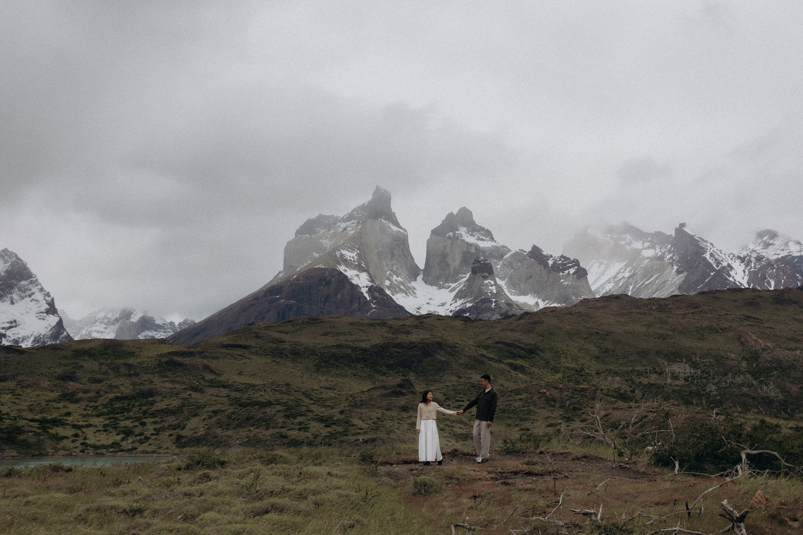 Couple standing beneath Torres del Paine mountains