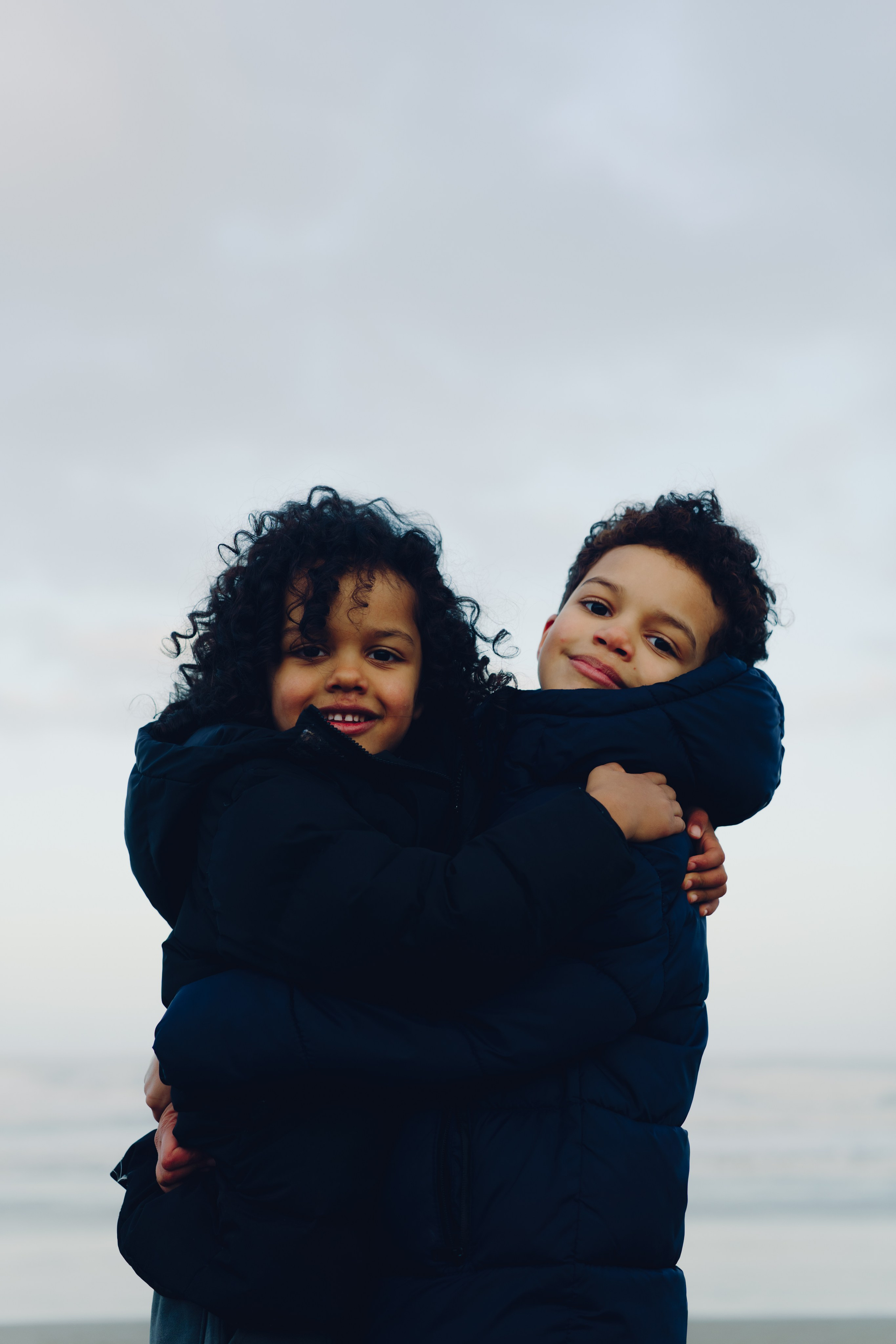 Siblings laughing together during a  family photoshoot in Tynemouth