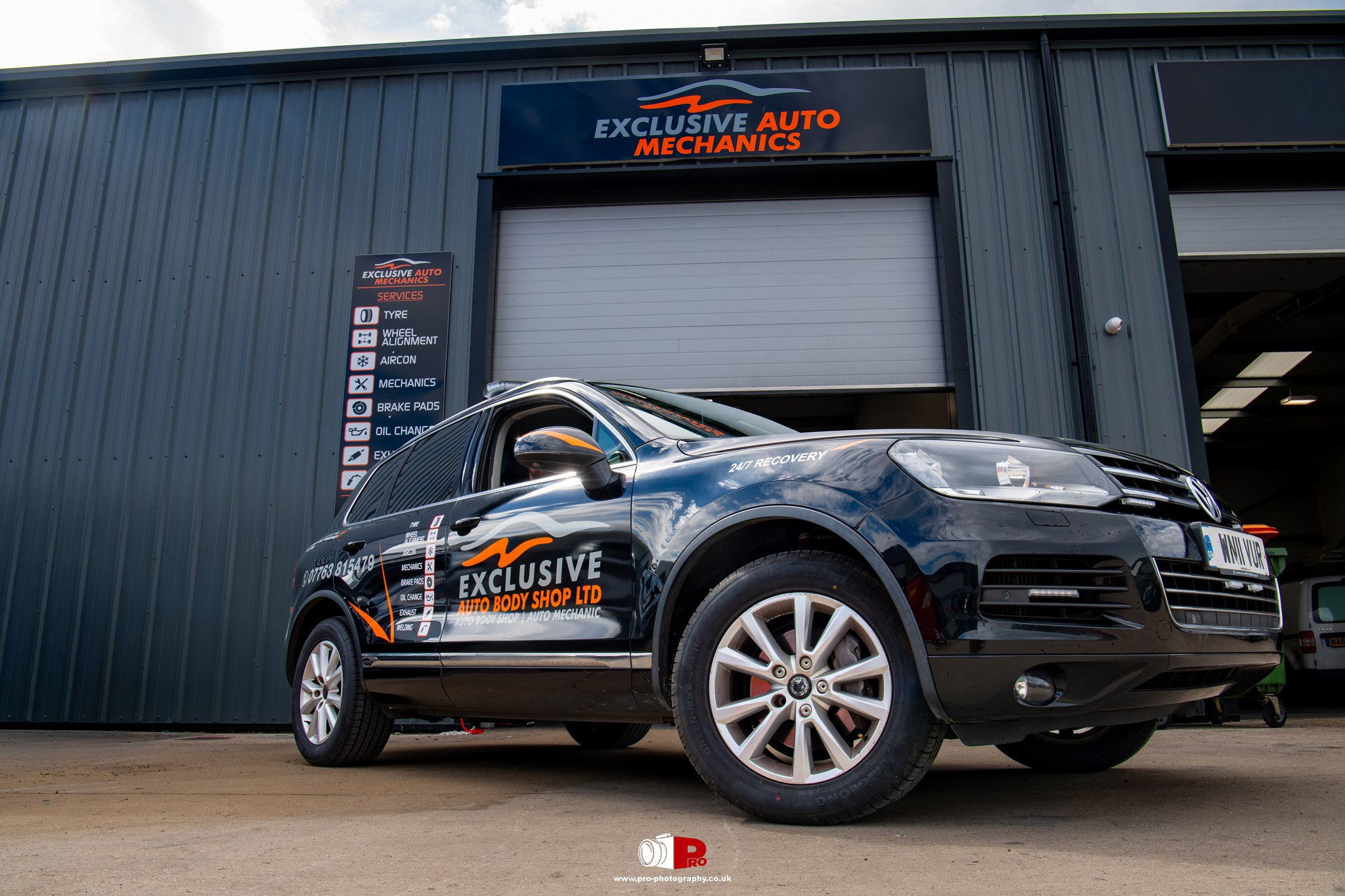 Commercial business image of an Exclusive Auto Mechanics recovery vehicle outside the automotive workshop.