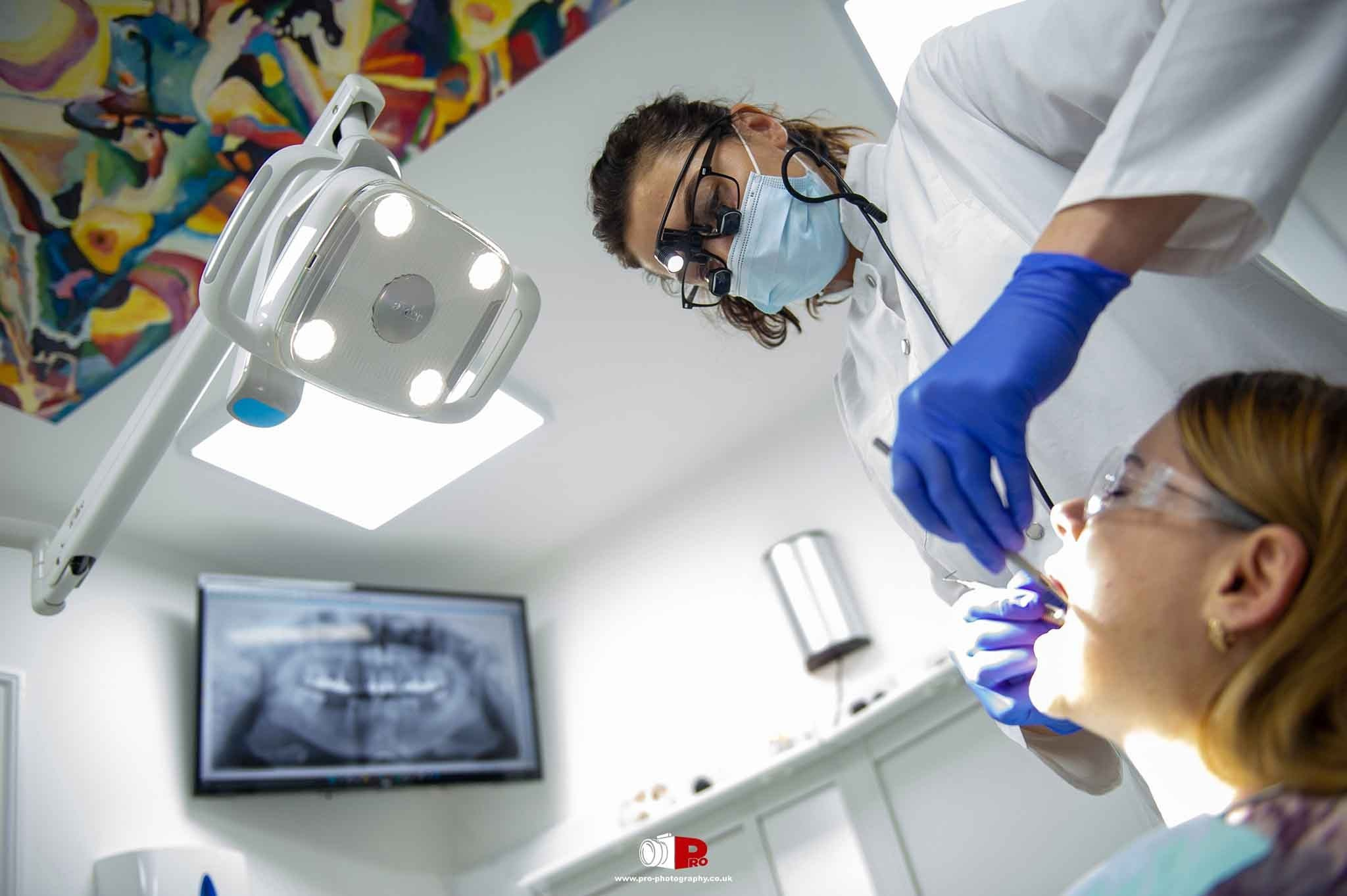 Commercial healthcare image of a dentist treating a patient in a modern dental surgery.