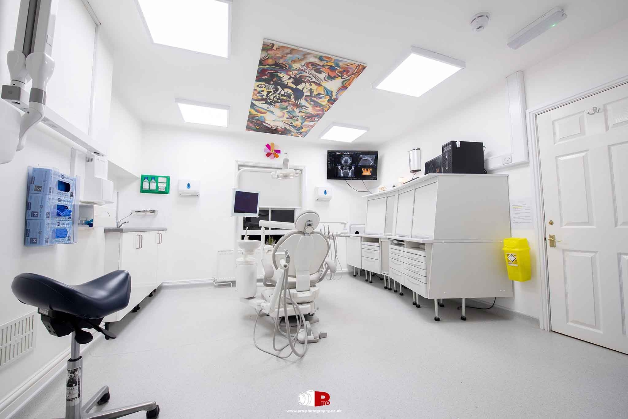 Commercial interior image of a bright modern dental treatment room with professional equipment.
