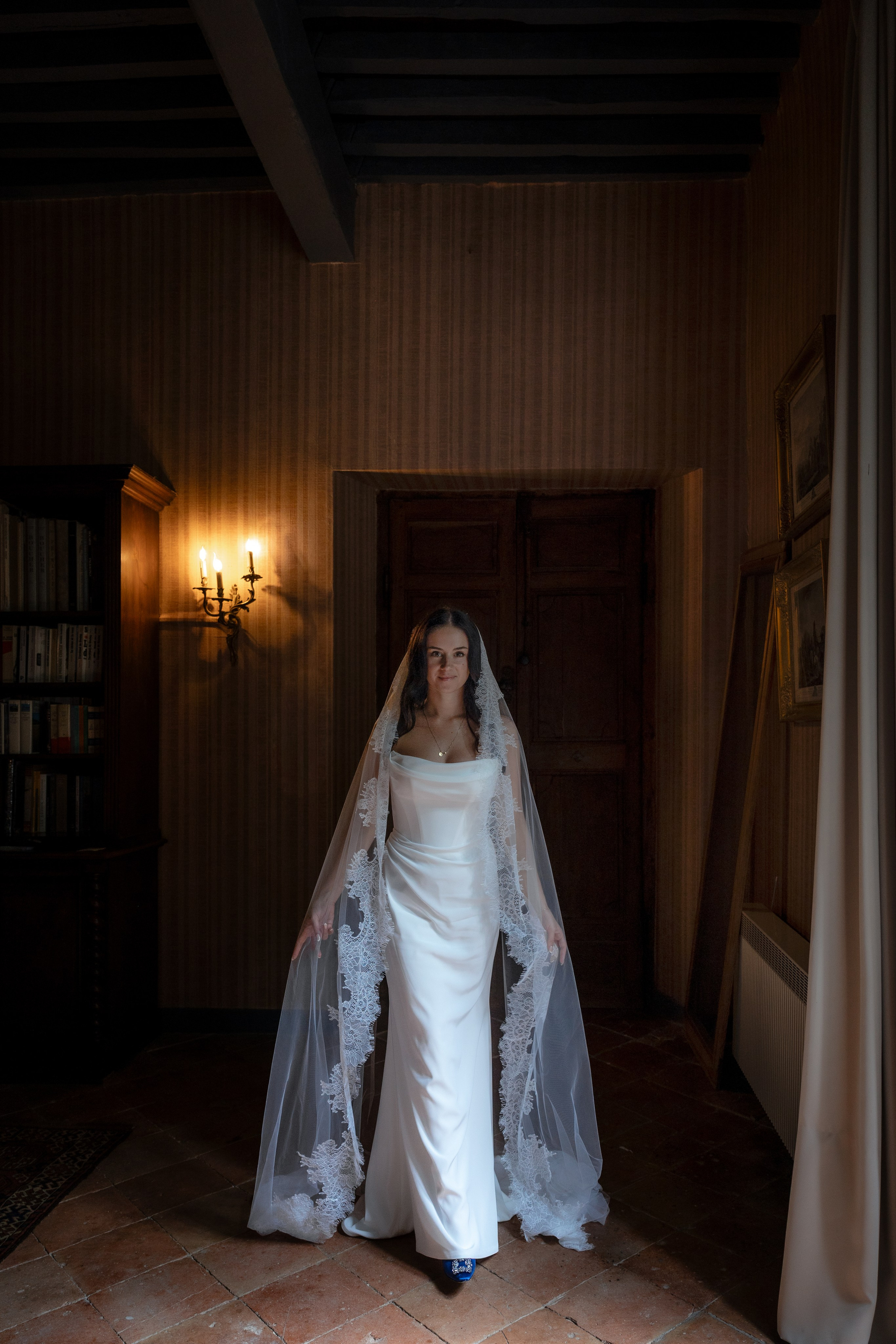 Bridal preparation in château suite with natural window light in Occitanie