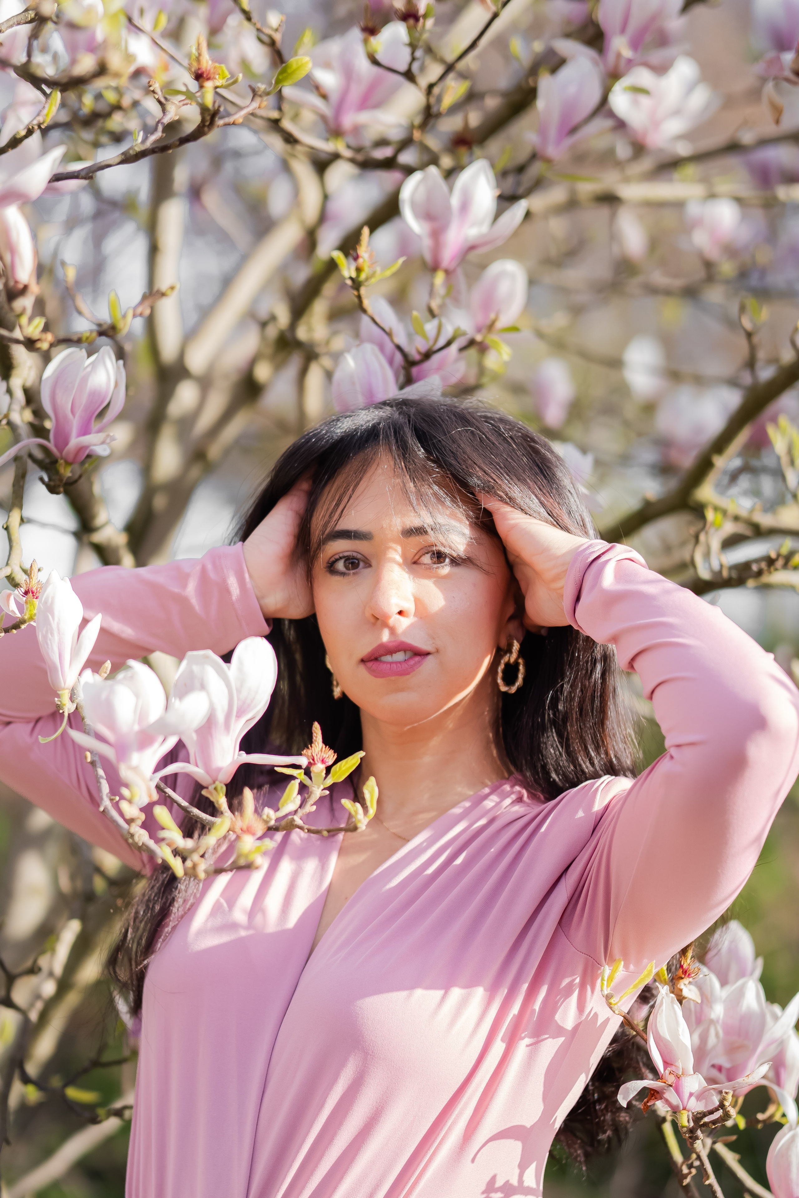 Woman standing underneath magnolia flowers