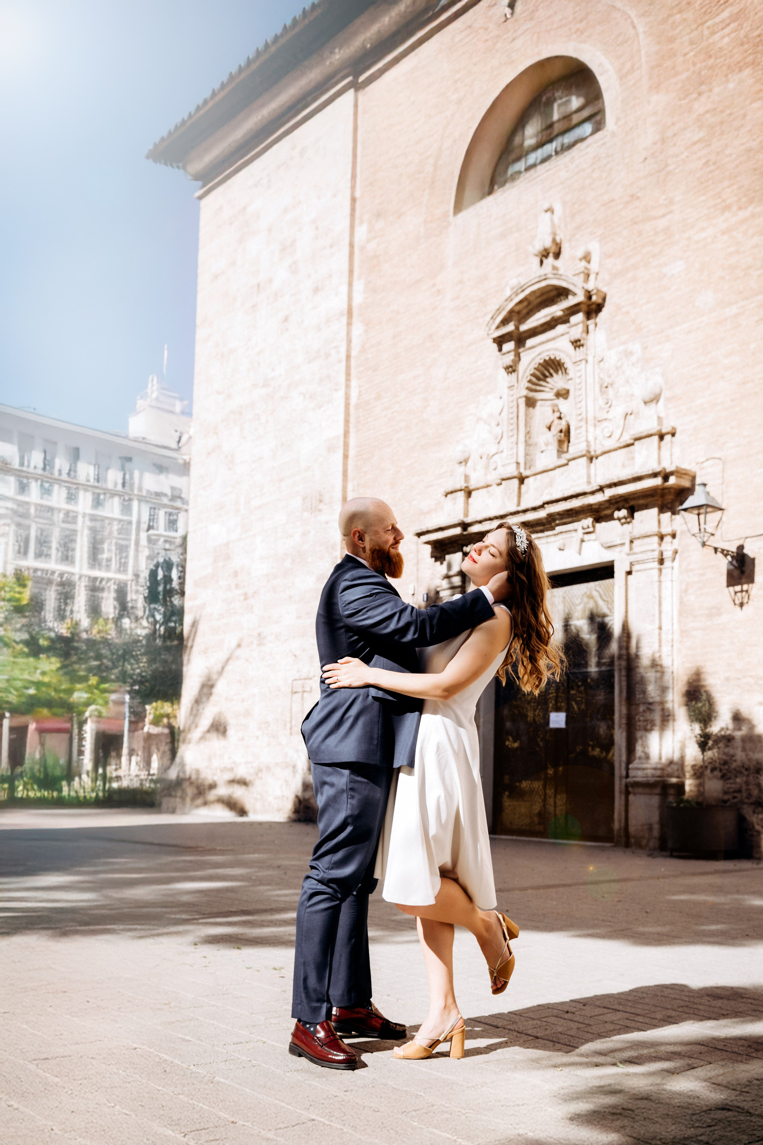 Newlyweds share a quiet embrace outside a historic church in València following their intimate civil wedding. The timeless architecture and soft Mediterranean light create a refined and romantic destination wedding atmosphere.