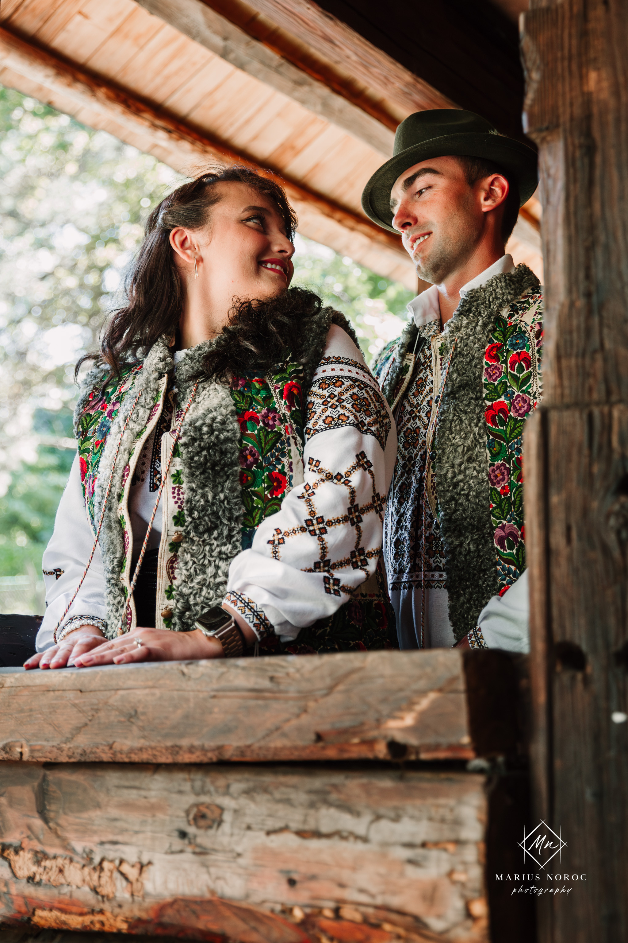 Sabina și Ionuț, îmbrăcați în costume populare bucovinene, au realizat o ședință foto "Save the Date" la Muzeul Satului Bucovinean din Suceava. Fotografii tradiționale și romantice, surprinse într-un peisaj autentic și istoric, evidențiind dragostea și frumusețea tradițiilor locale.